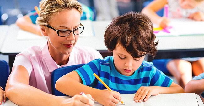 A teacher putting a student through his work in the classroom | Photo: Shutterstock