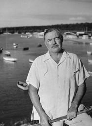 Ernest Hemingway pictured in  front of harbor dotted with small boats. | Photo: Getty Images