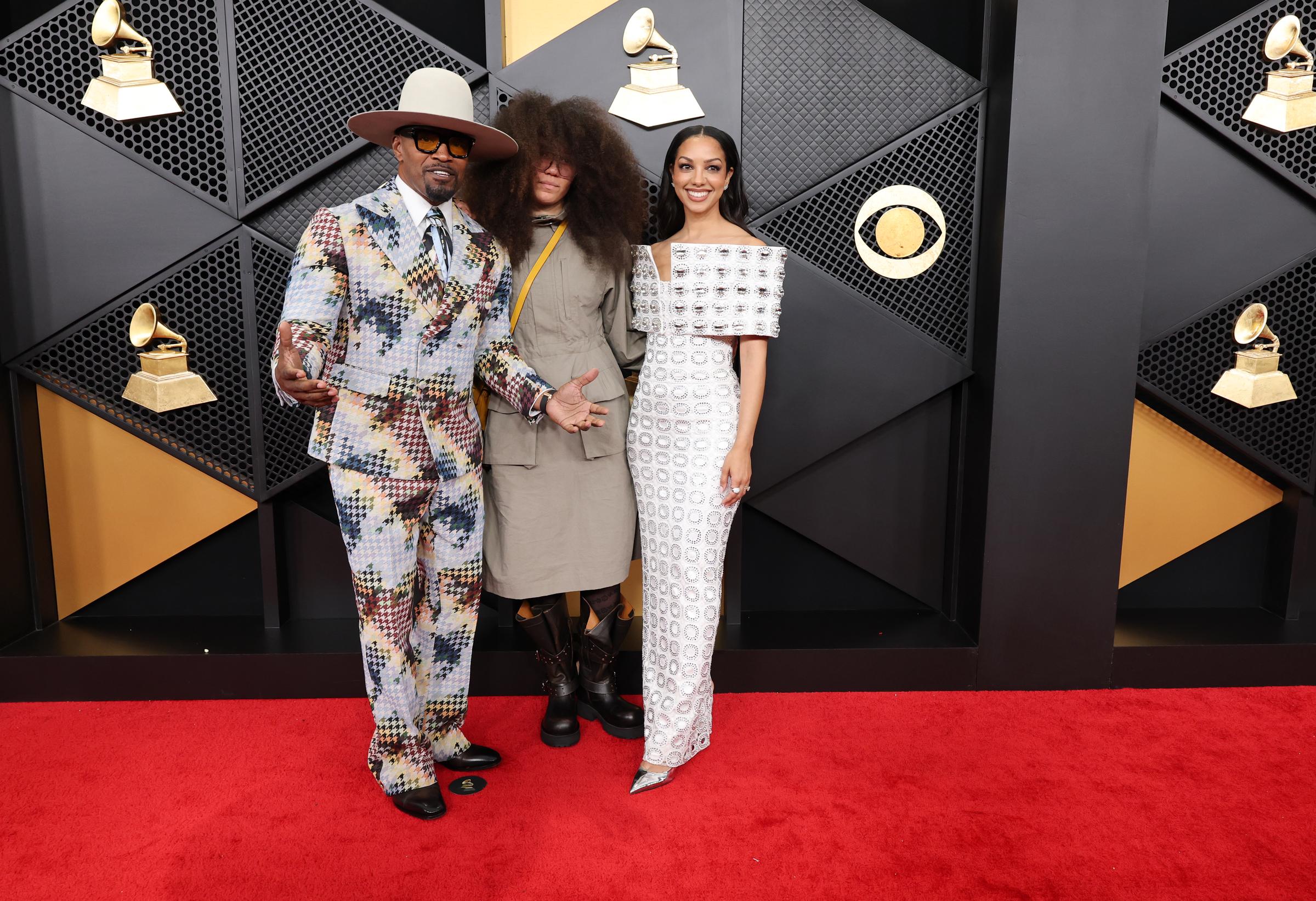 Jamie Foxx with daughters Corinne and Annalise stand together and face photographers along the carpet | Source: Getty Images