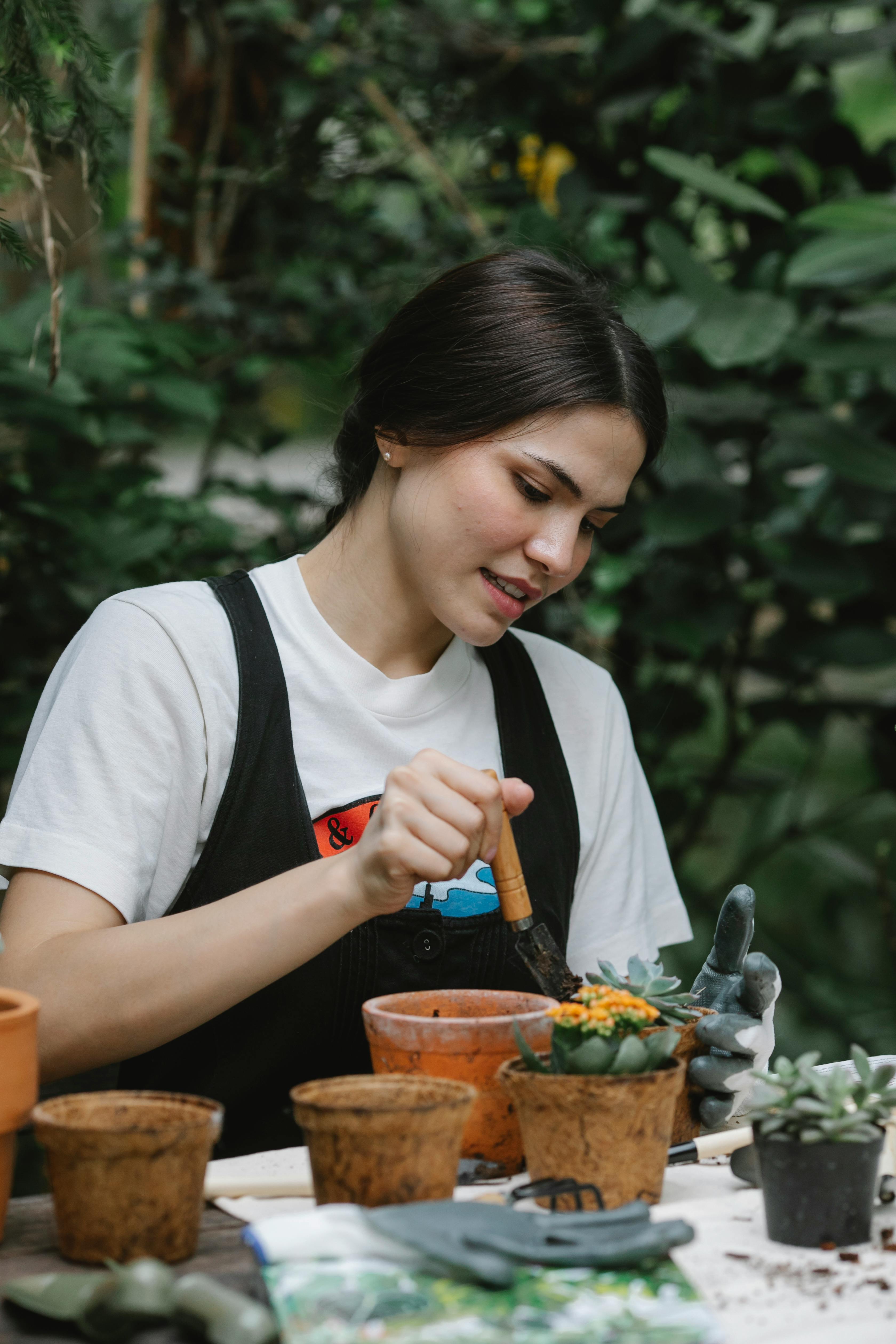 A woman repotting her plants | Source: Pexels