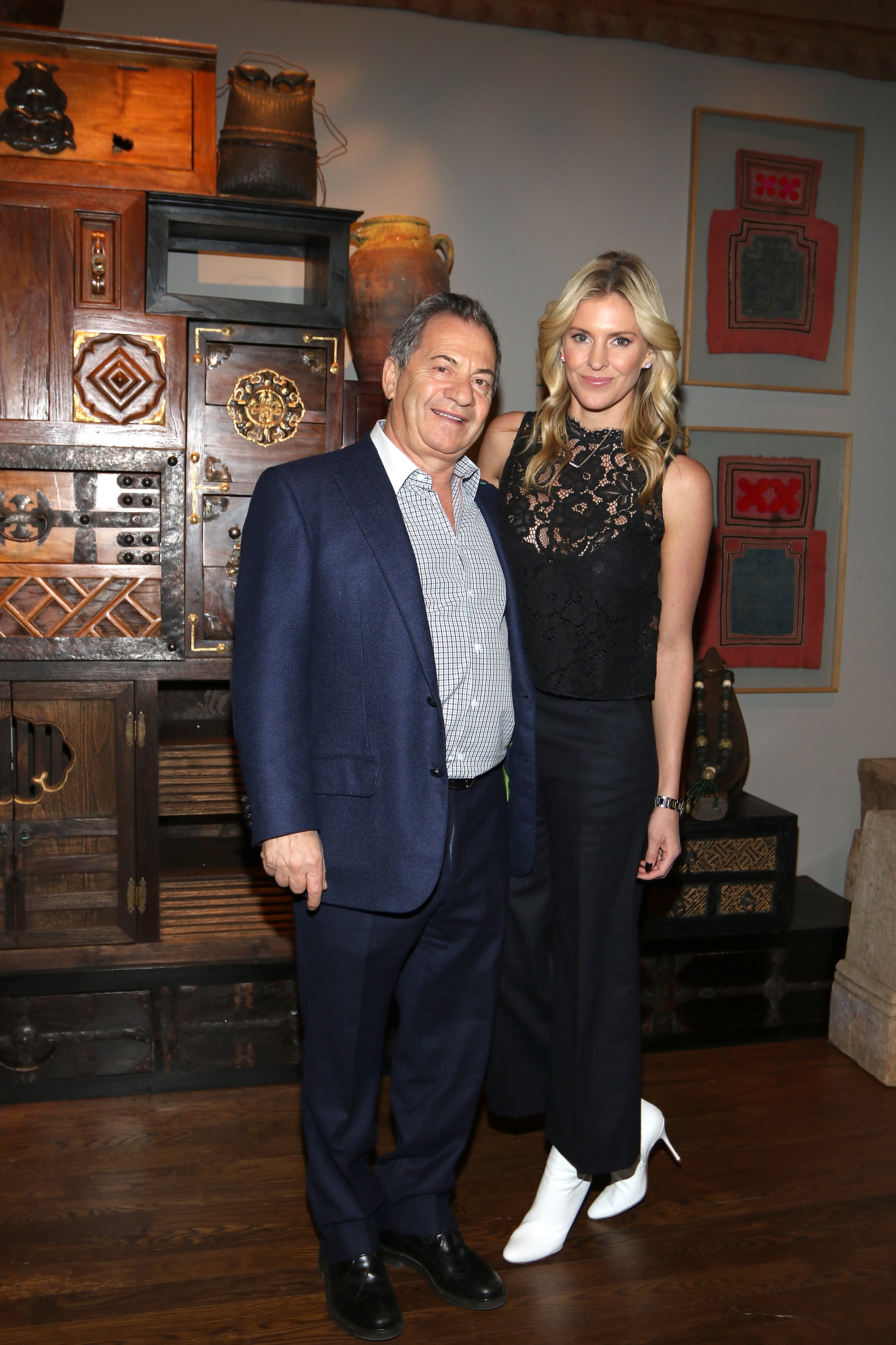 At the Urban Zen Holiday Experience in New York, Alec Gores and Kelly Noonan Gores posed side by side ahead of the premiere screening of Heal Documentary. She stood out in a sleeveless lace top and white boots, while he kept things classic in a checkered shirt and navy blazer.