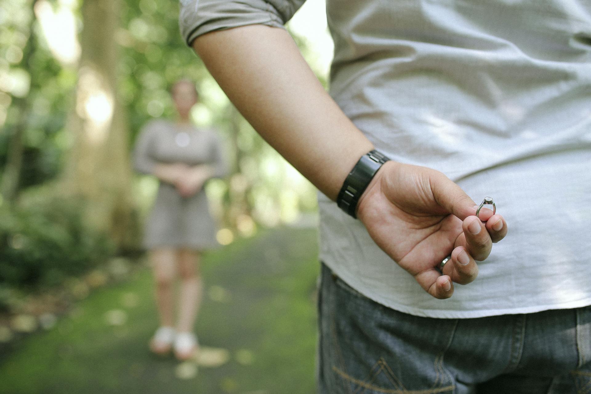 A man hides an engagement ring behind his back | Source: Pexels