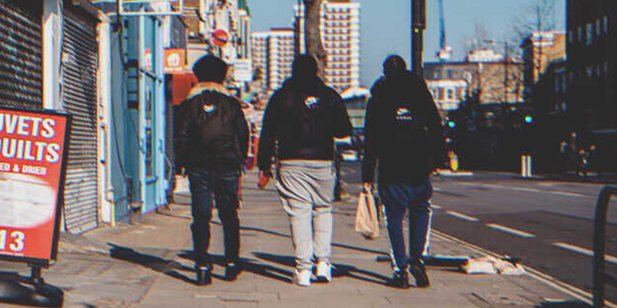Three young guys walking down the street | Source: Shutterstock