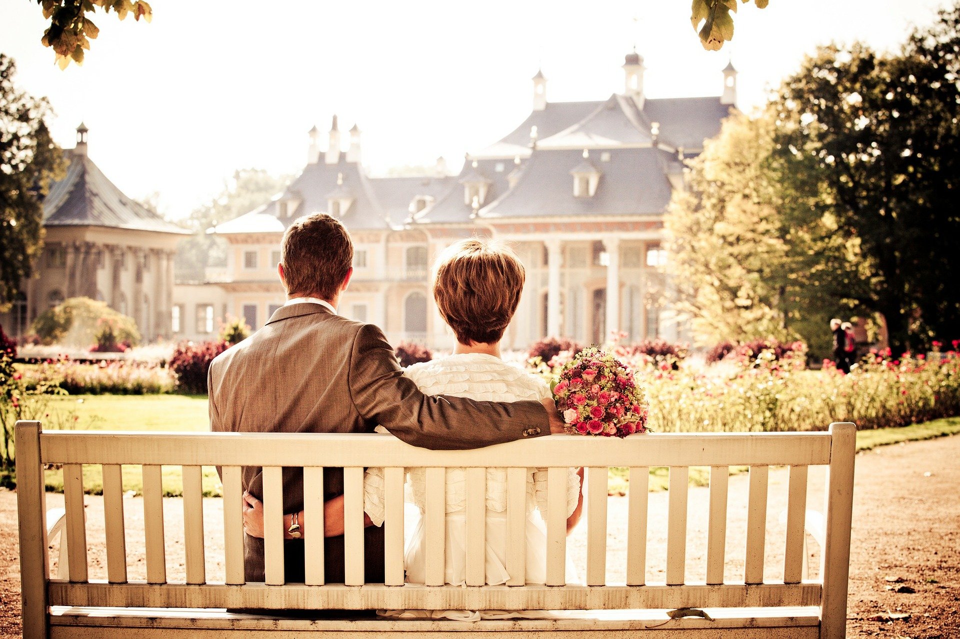 Couple sitting on a bench with their arms wrapped around each other | Source: Pixabay