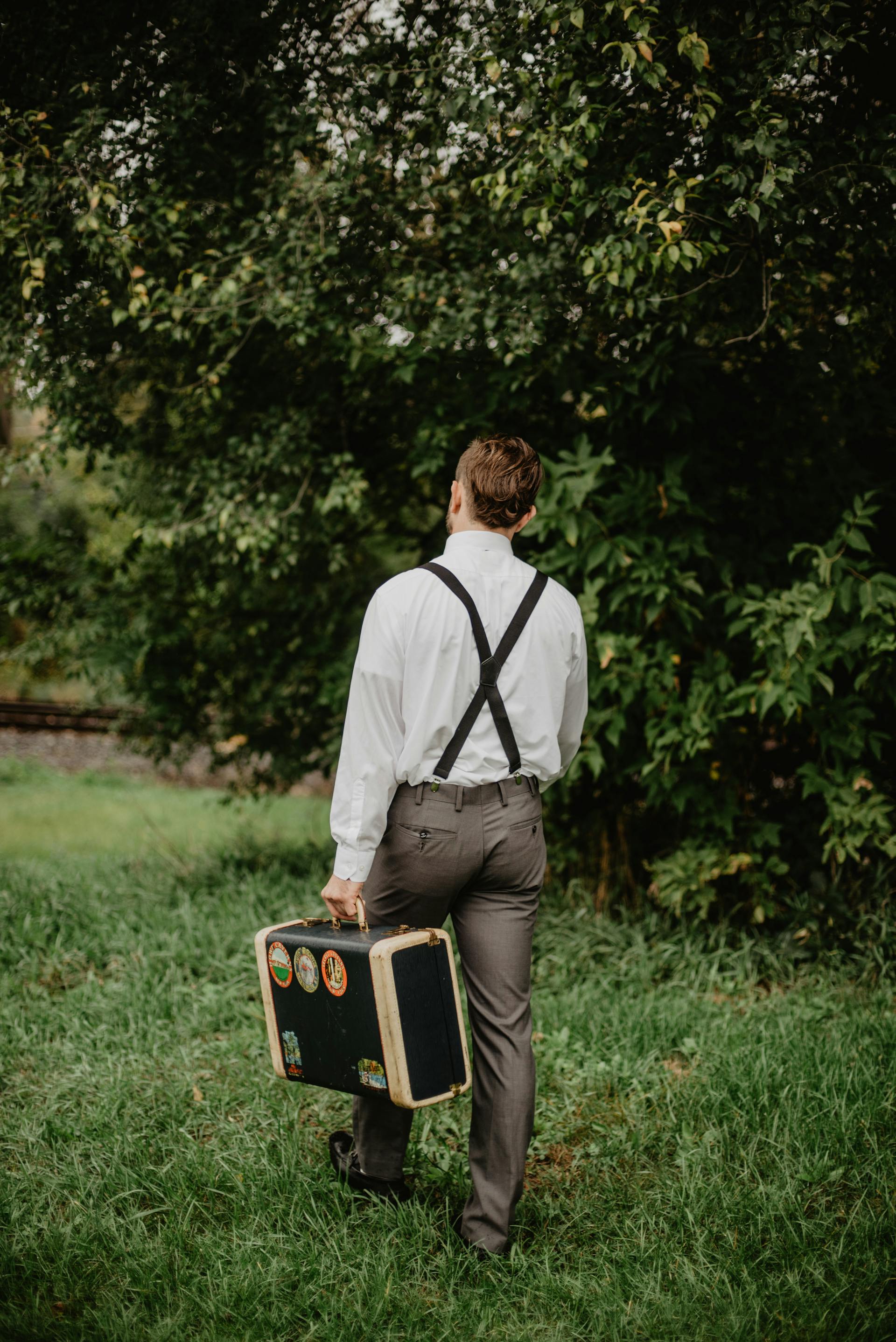 A man walking away with a suitcase | Source: Pexels