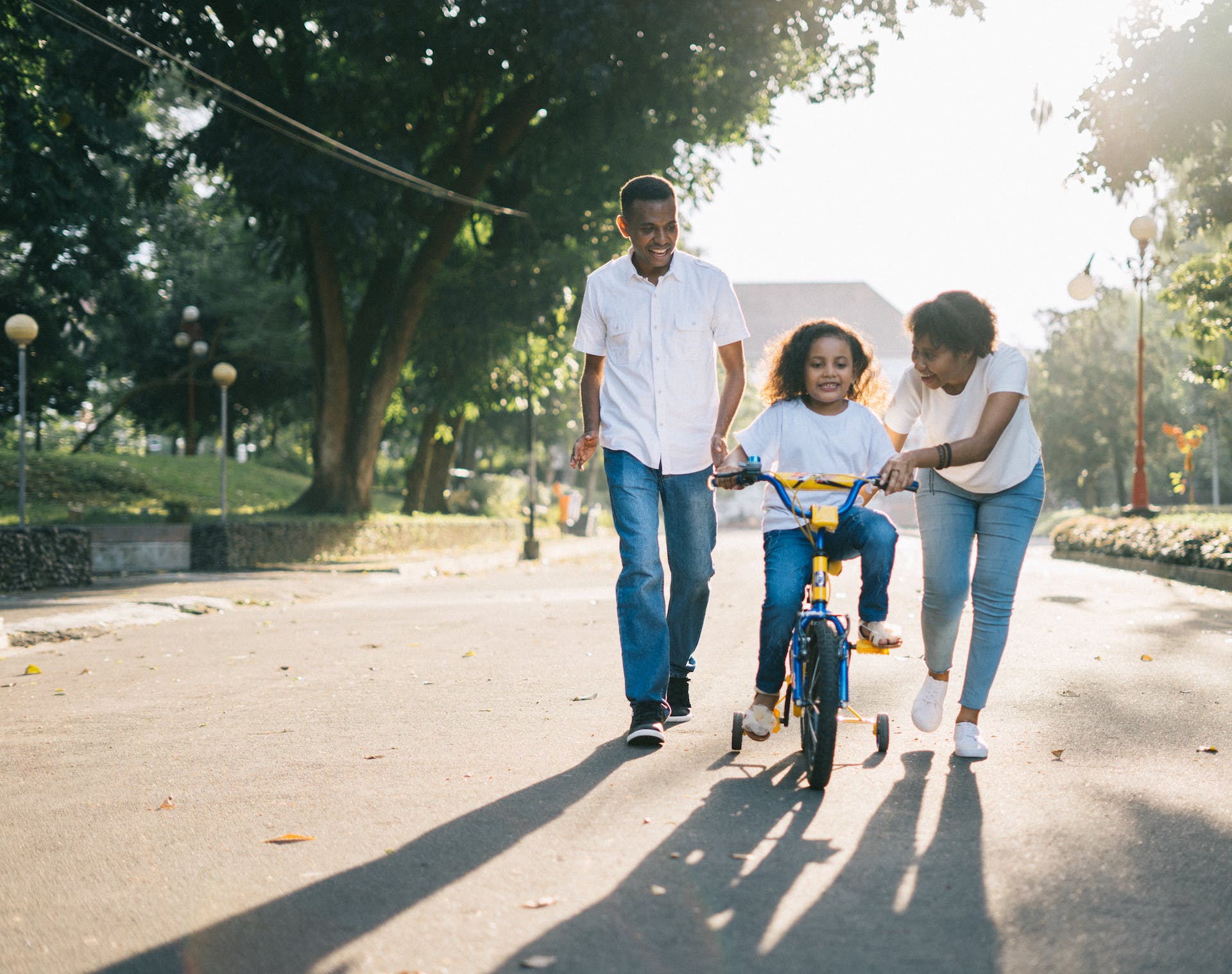 A couple teaching a girl how to ride a bicycle | Source: Pexels