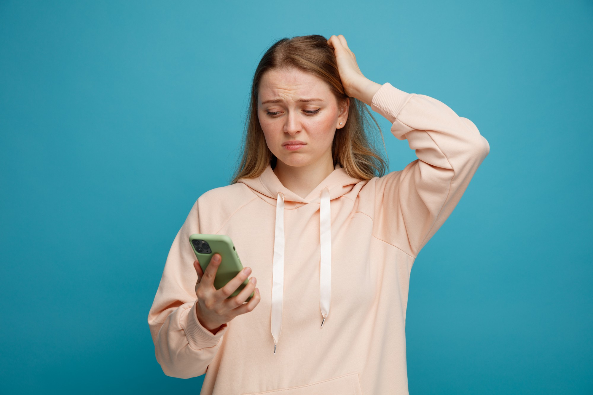 An upset woman looking at her phone and holding her head | Source: Freepiks