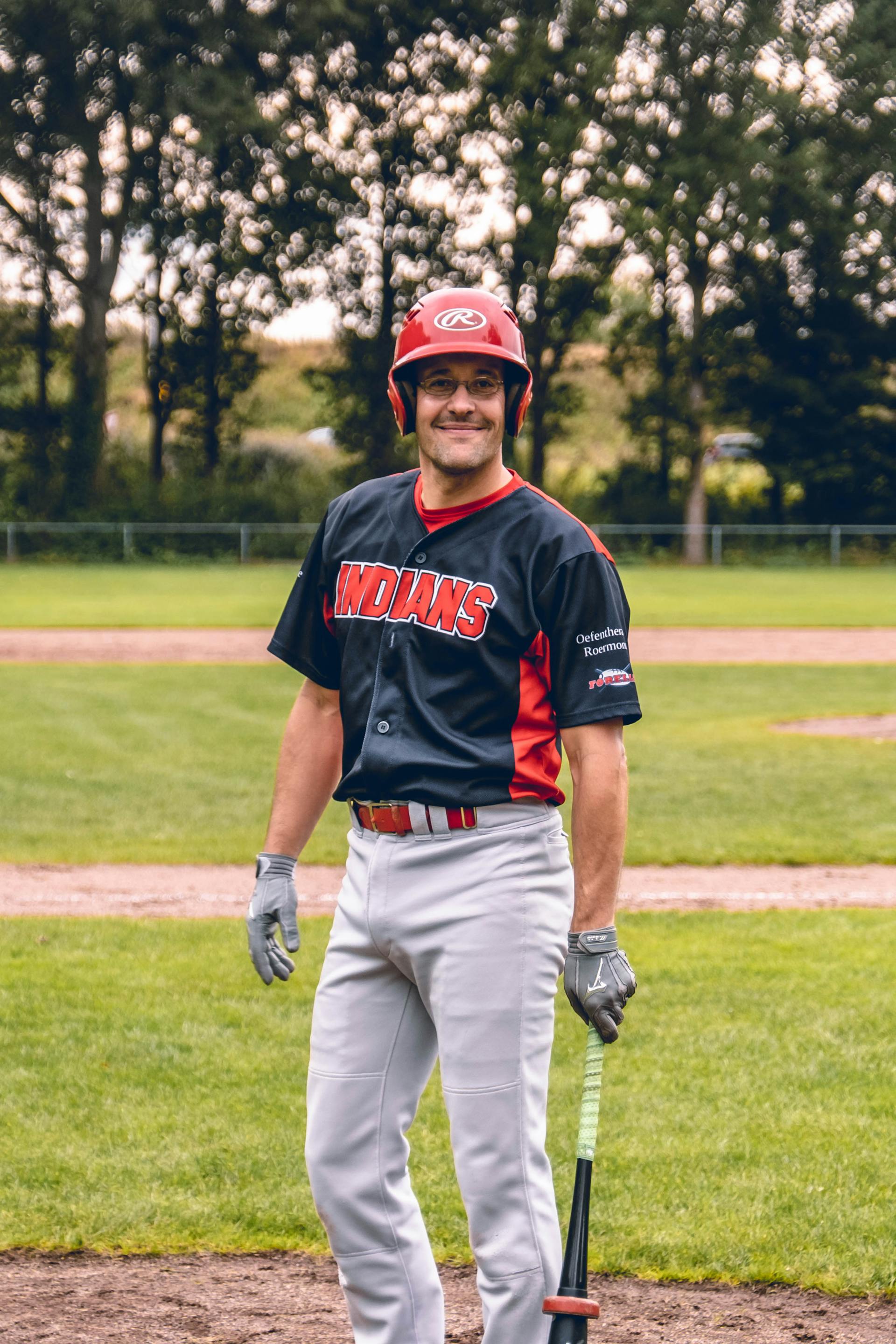 A man in baseball uniform standing and smiling outdoors | Source: Pexels