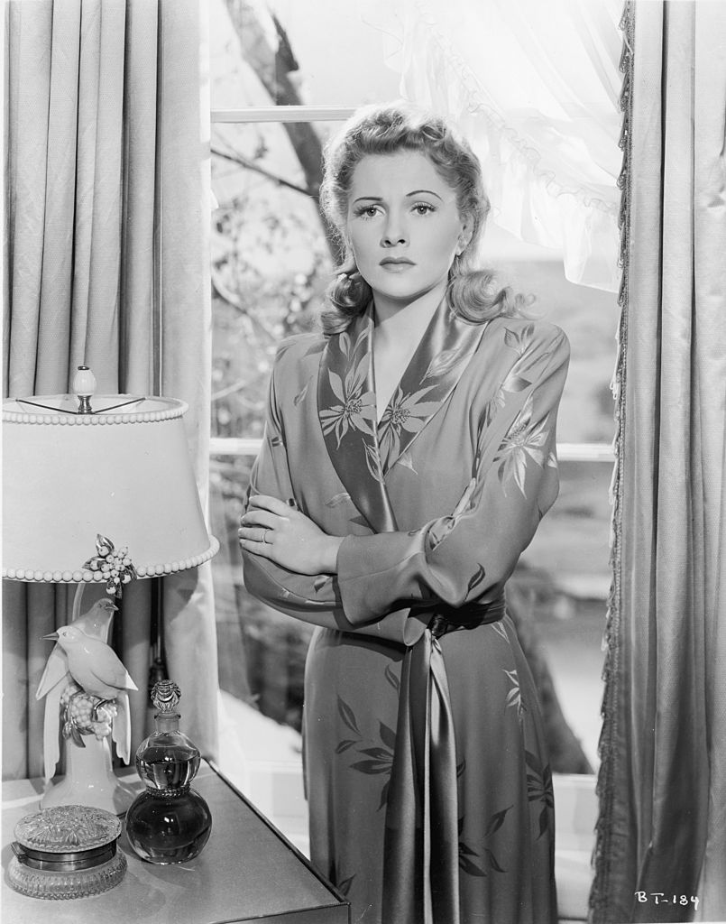 1941: Japanese-born American actor Joan Fontaine stands with her back to a window in a still from the film 'Suspicion,' directed by Alfred Hitchcock. | Source: Getty Images