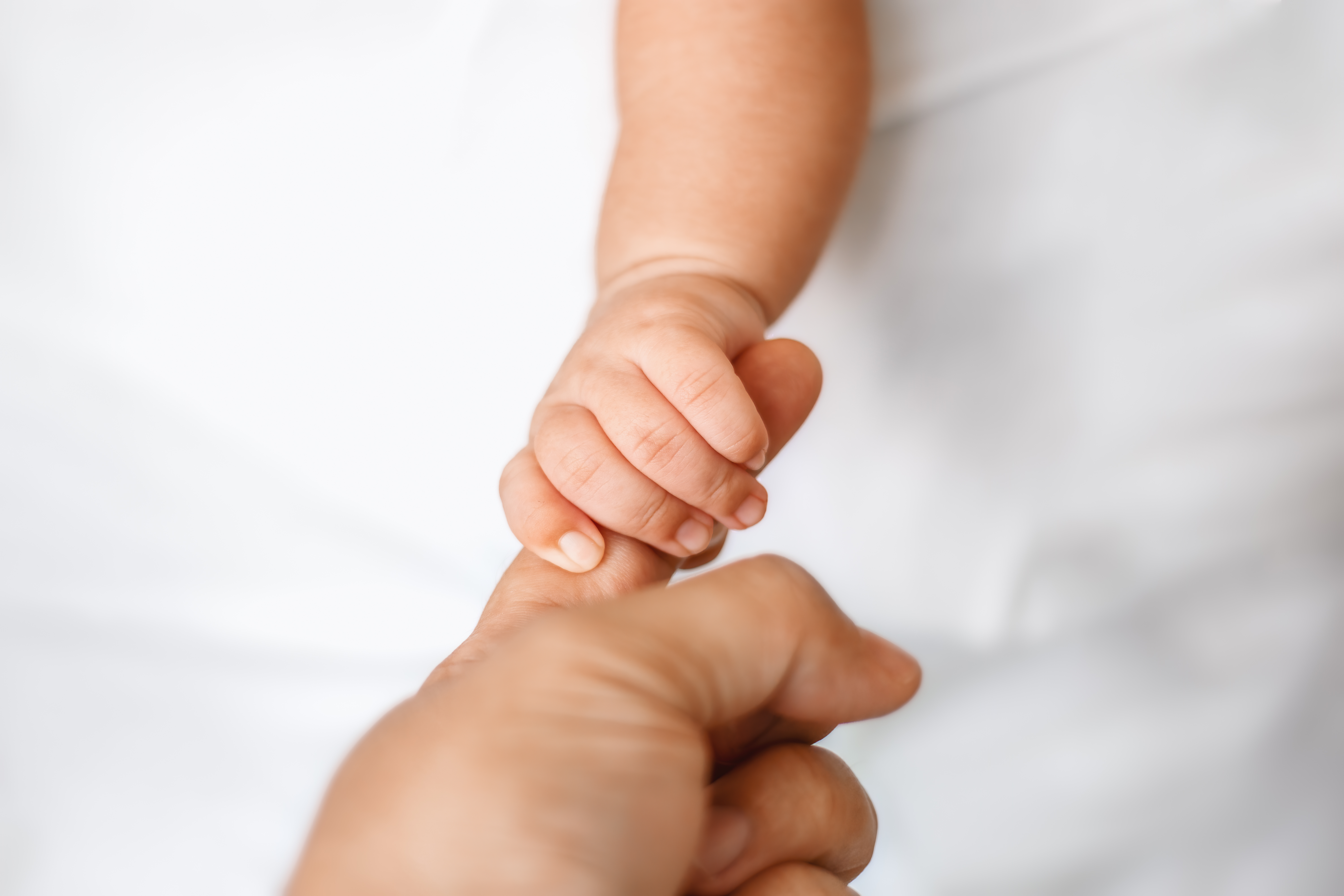 A newborn baby holding an adult finger | Source: Getty Images