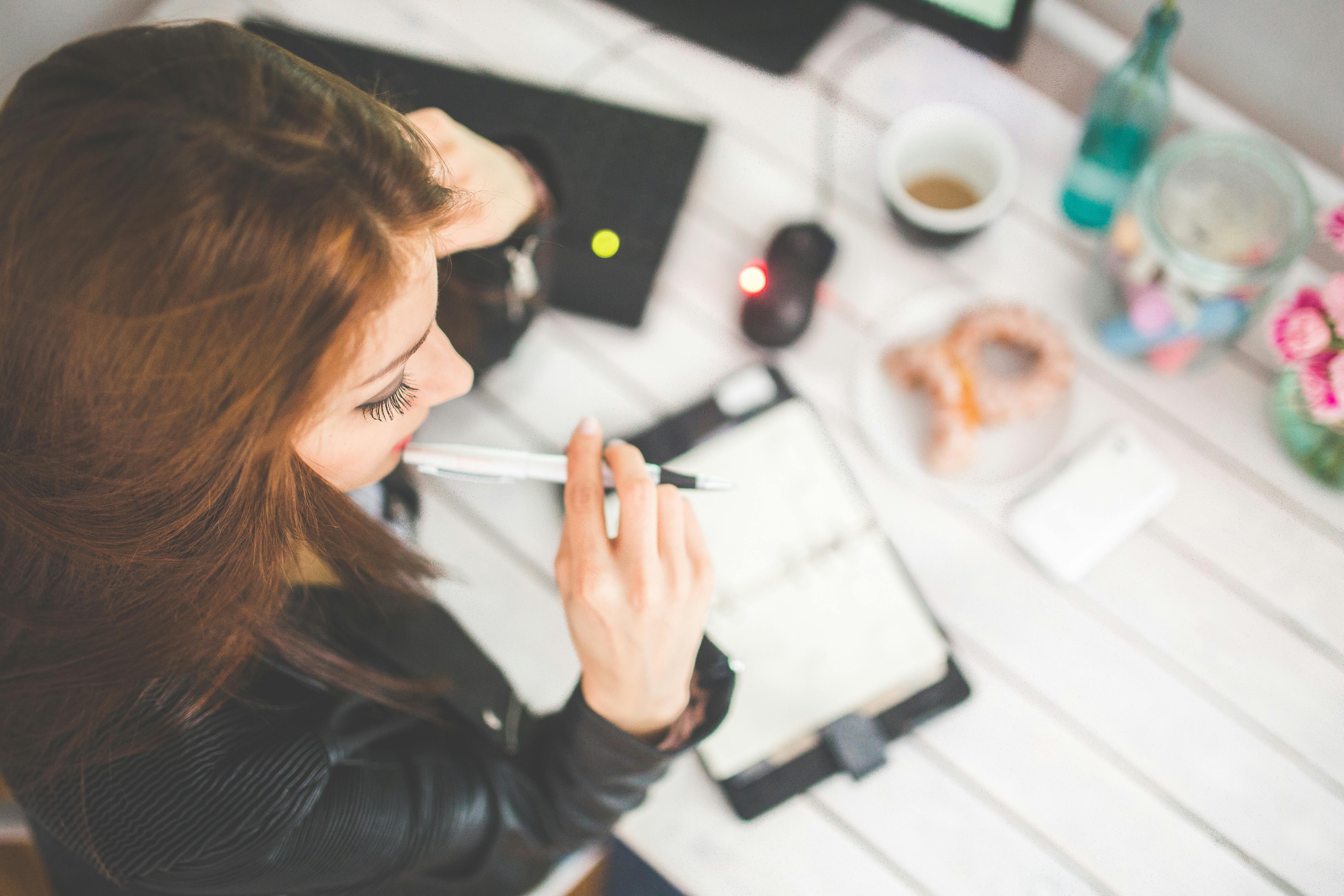 A woman deep in thought at her desk | Source: Pexels