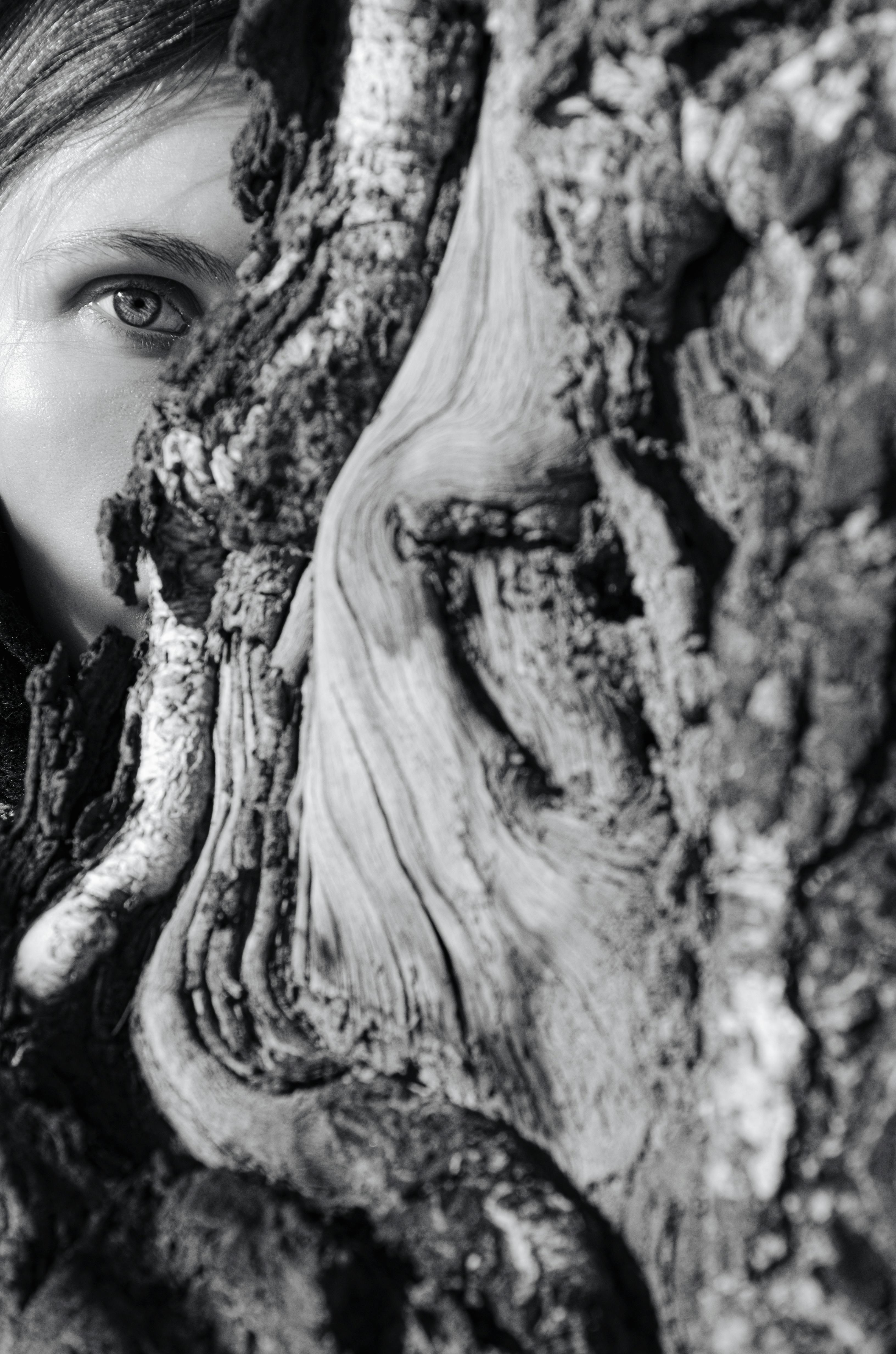 A woman hiding behind a tree | Source: Pexels