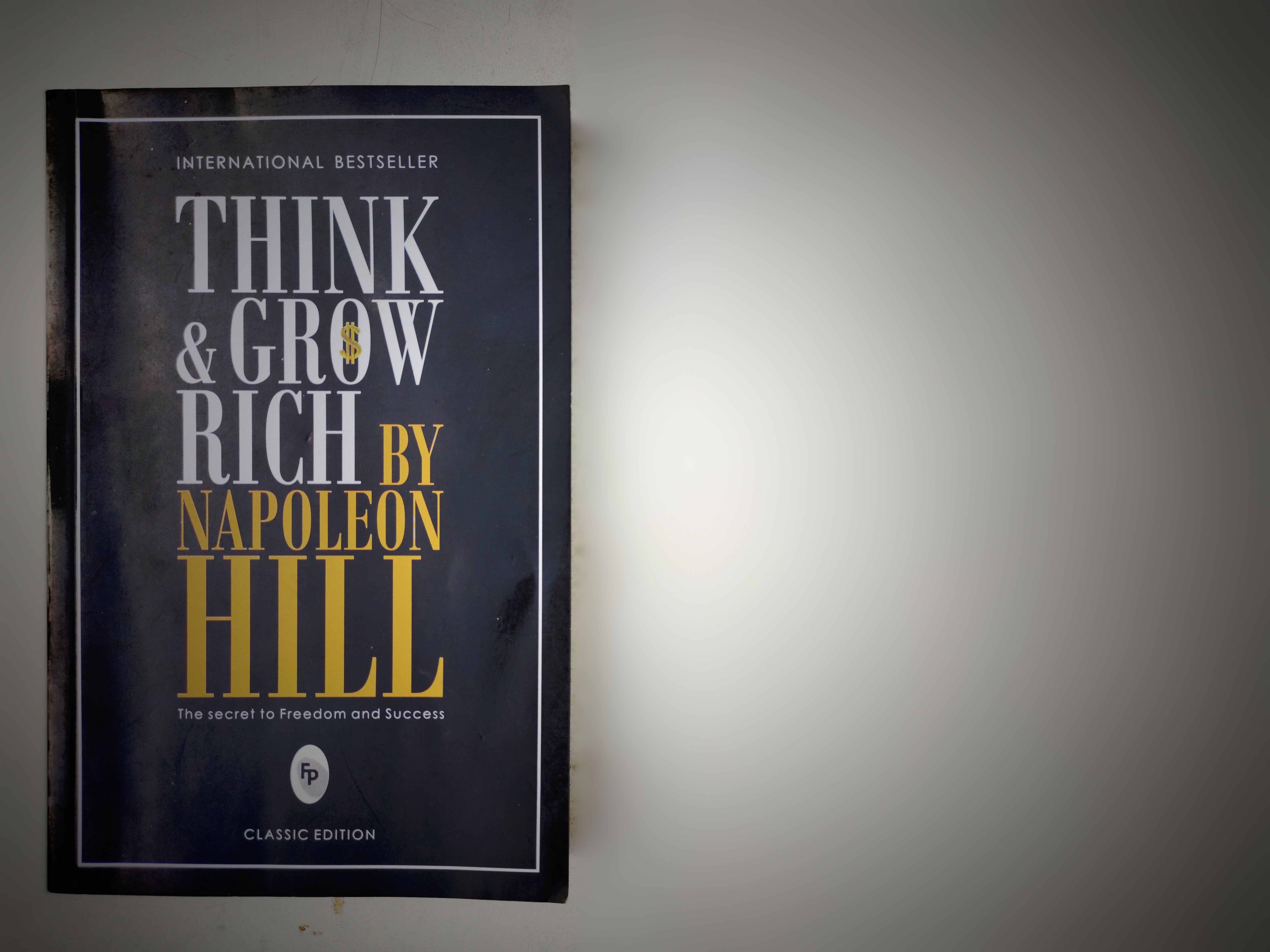 A copy of "Think & Grow Rich" by Napoleon Hill on a flat surface | Source: Shutterstock