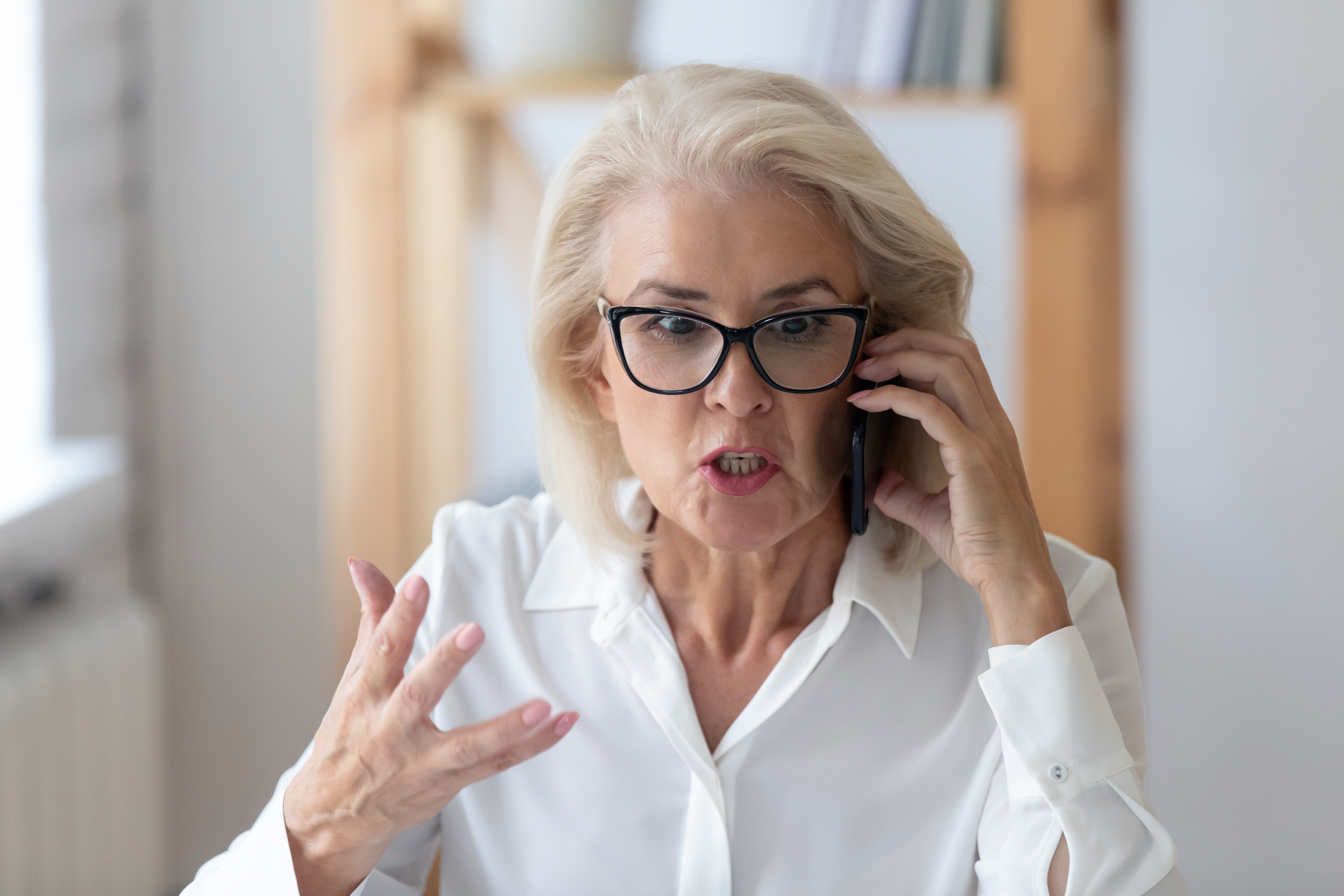 An angry elderly woman on the phone | Source: Shutterstock