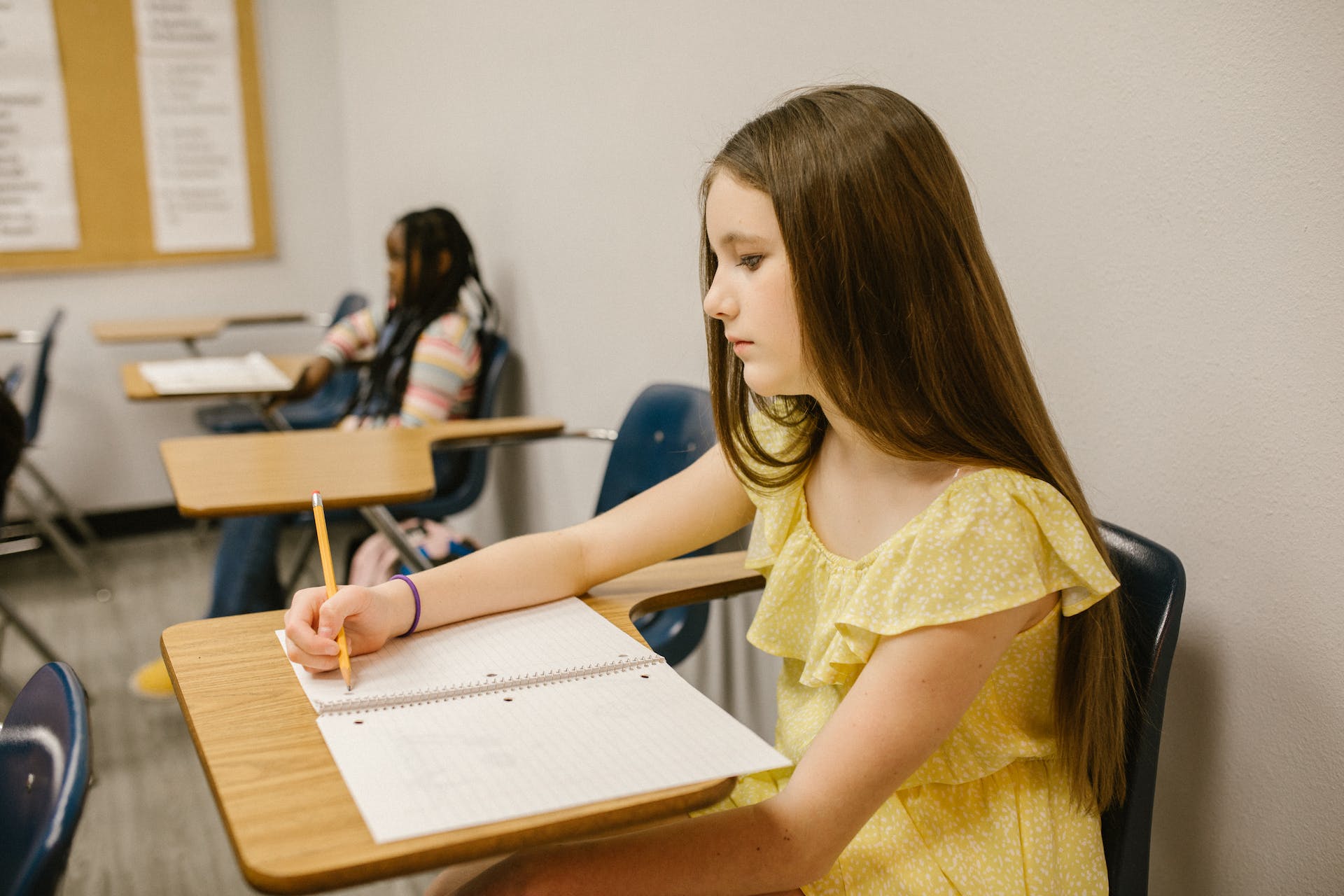 A lonely young girl sitting in a classroom | Source: Pexels