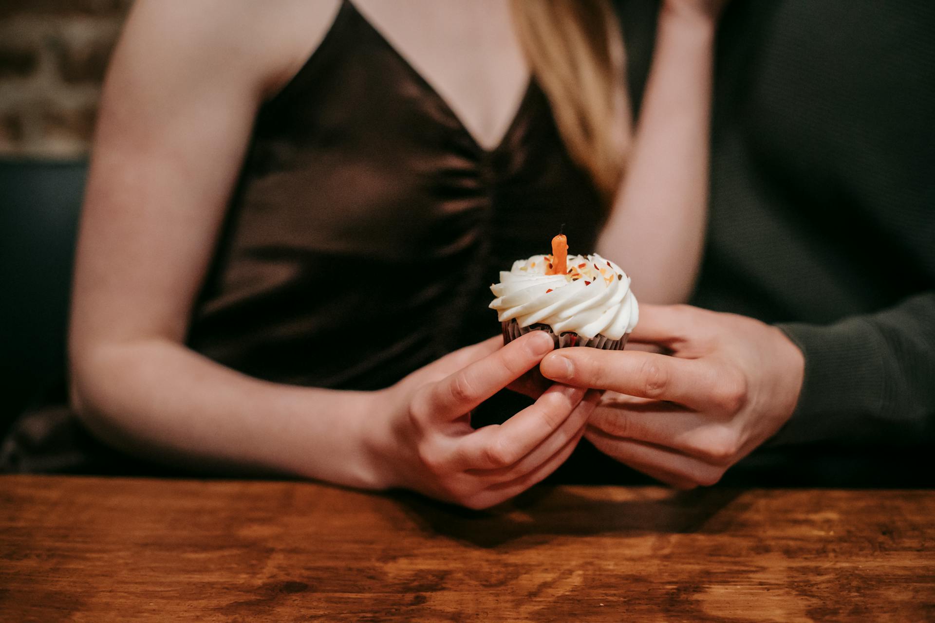 A couple celebrating with a cupcake in a restaurant | Source: Pexels