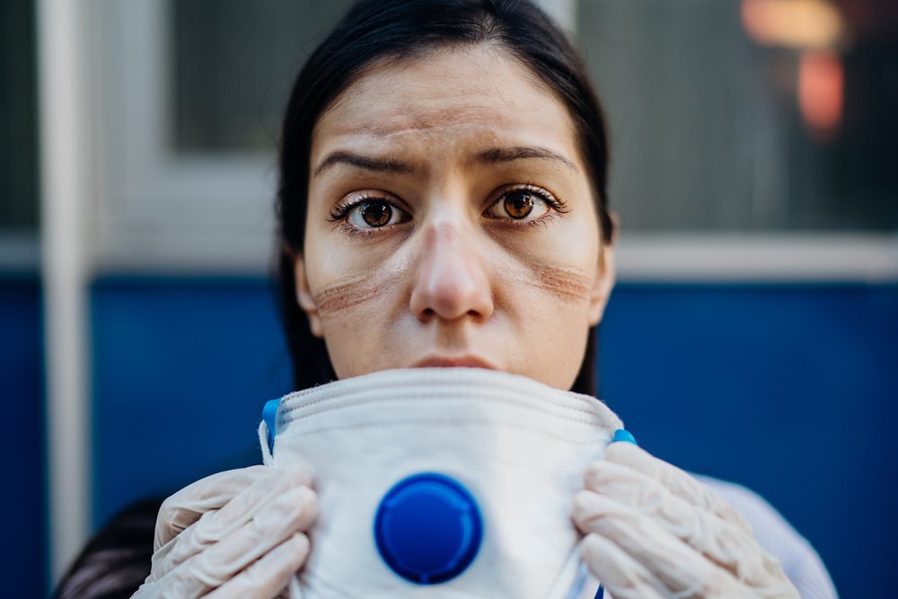 Enfermera agotada tomando equipo protector. I Foto: Shutterstock