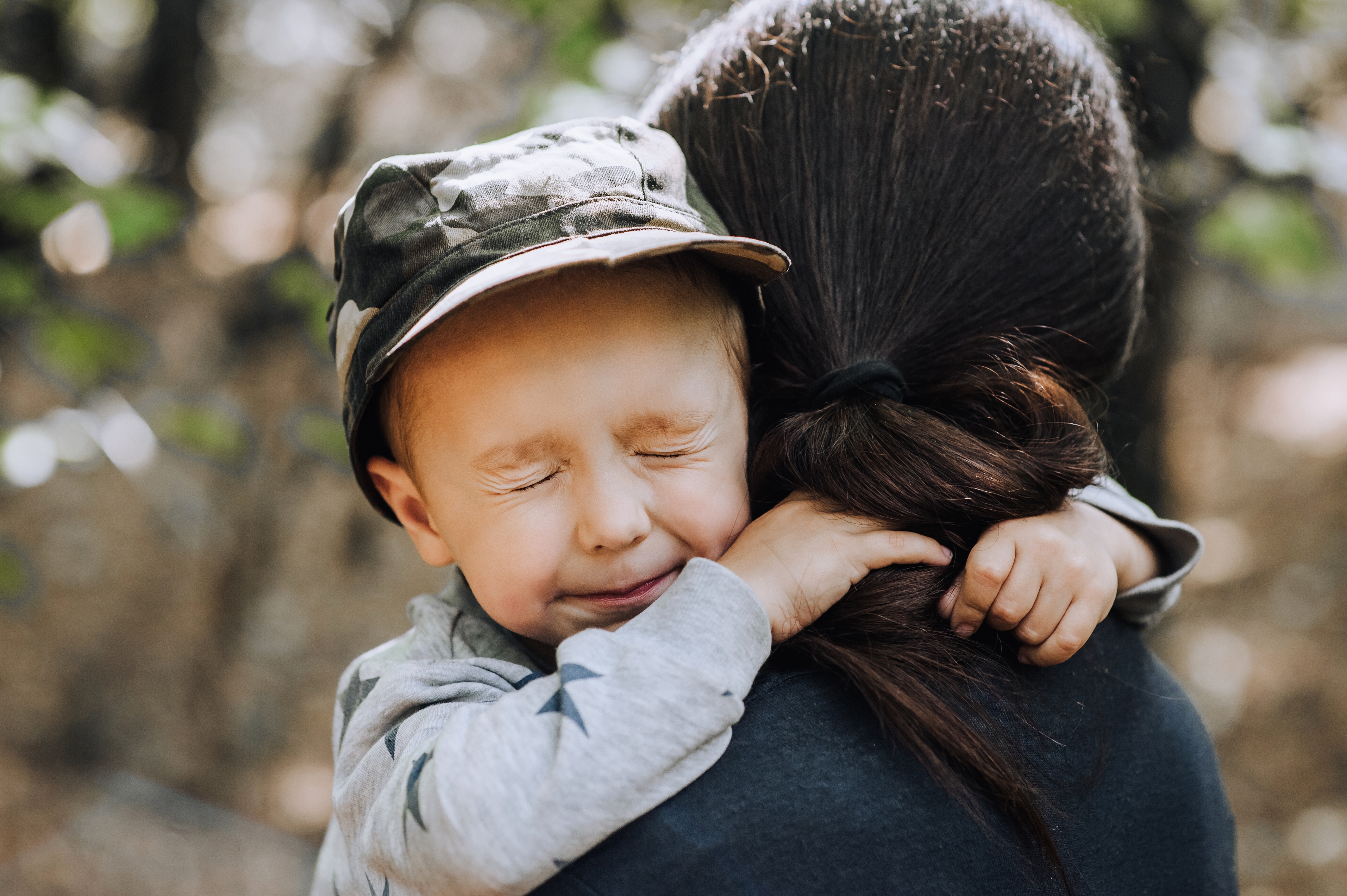 A little boy hugging a woman with his eyes squeezed shut | Source: Shutterstock