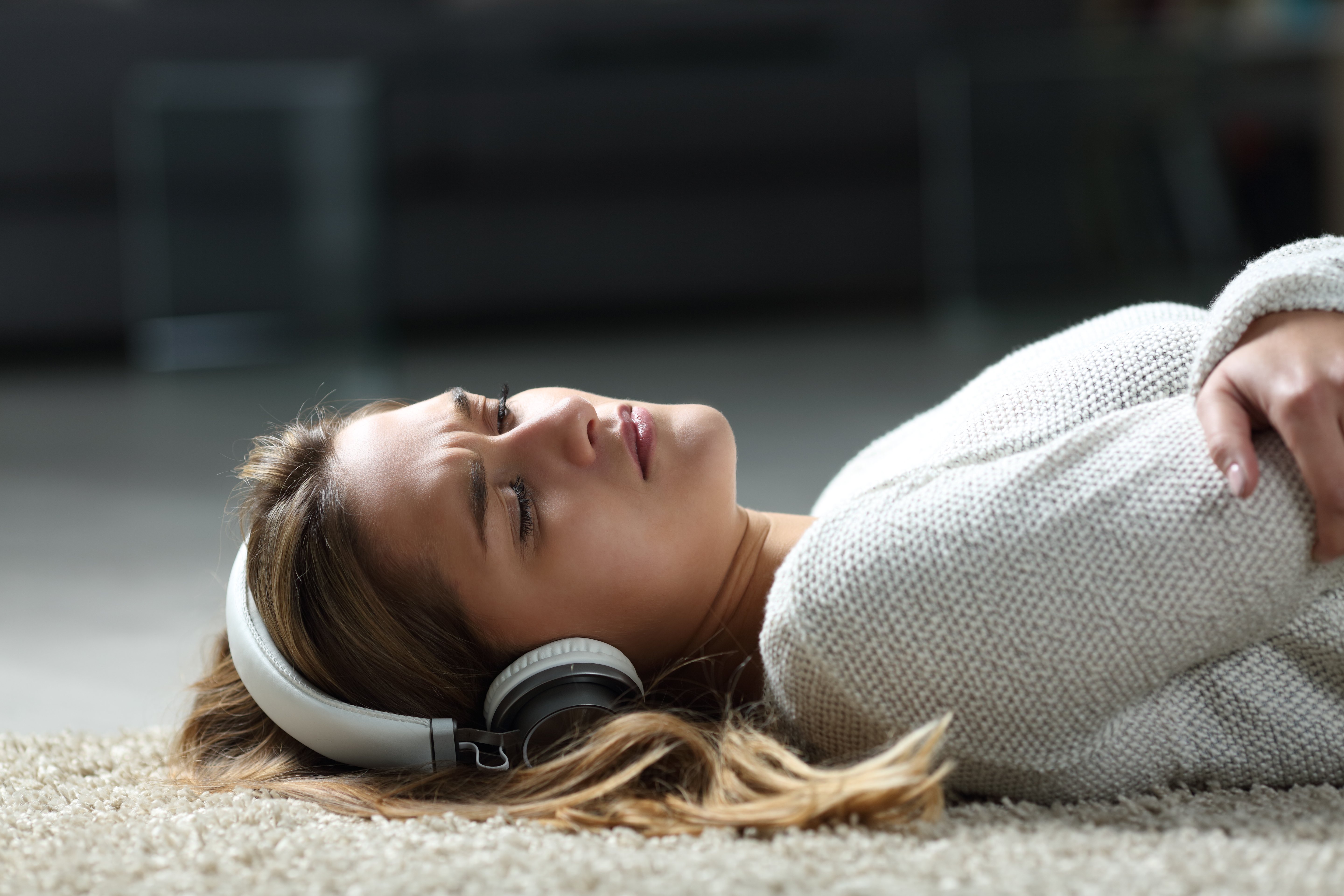 Sad woman listening to music on the floor | Source: Getty Images