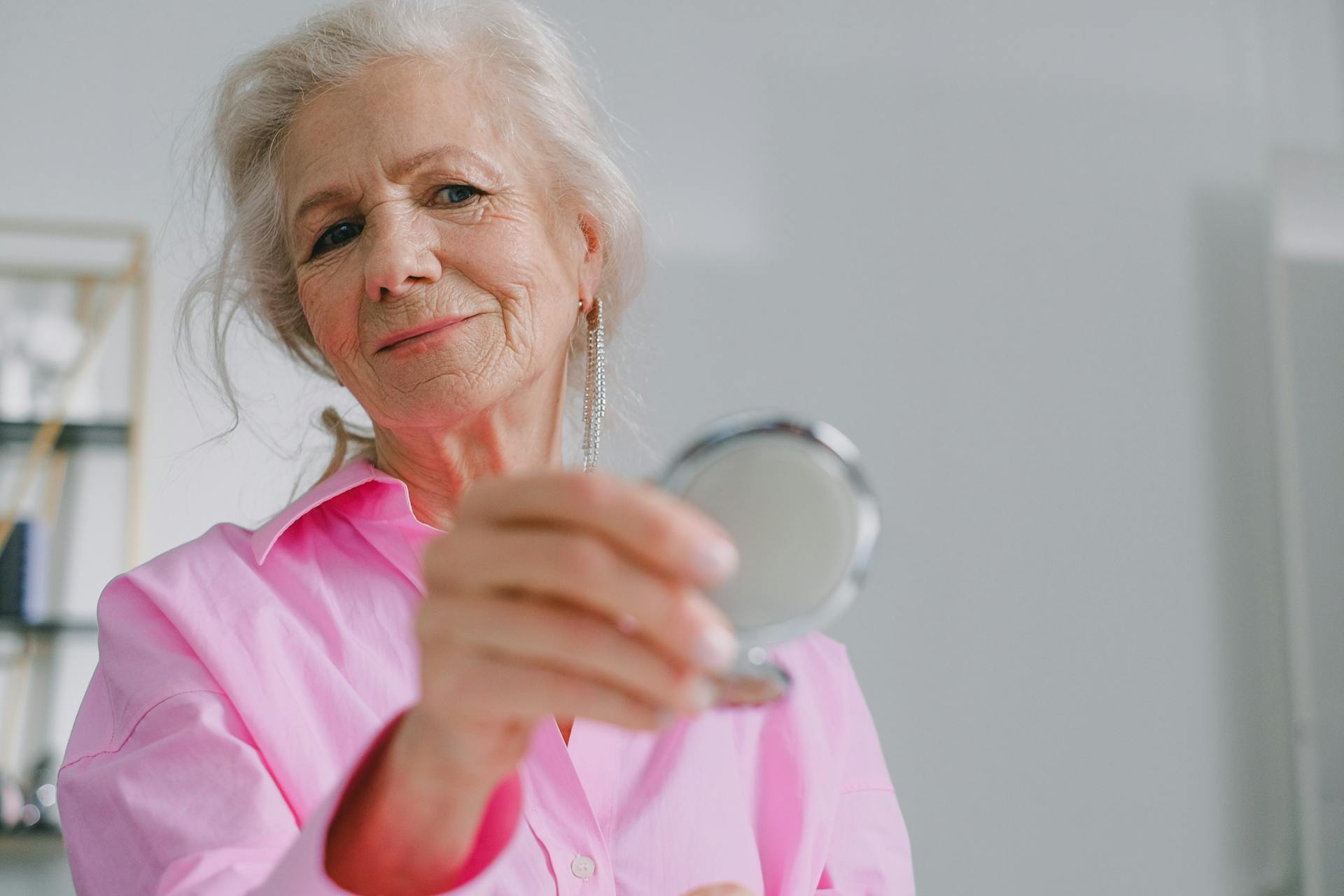 An older lady holding a small mirror | Source: Pexels