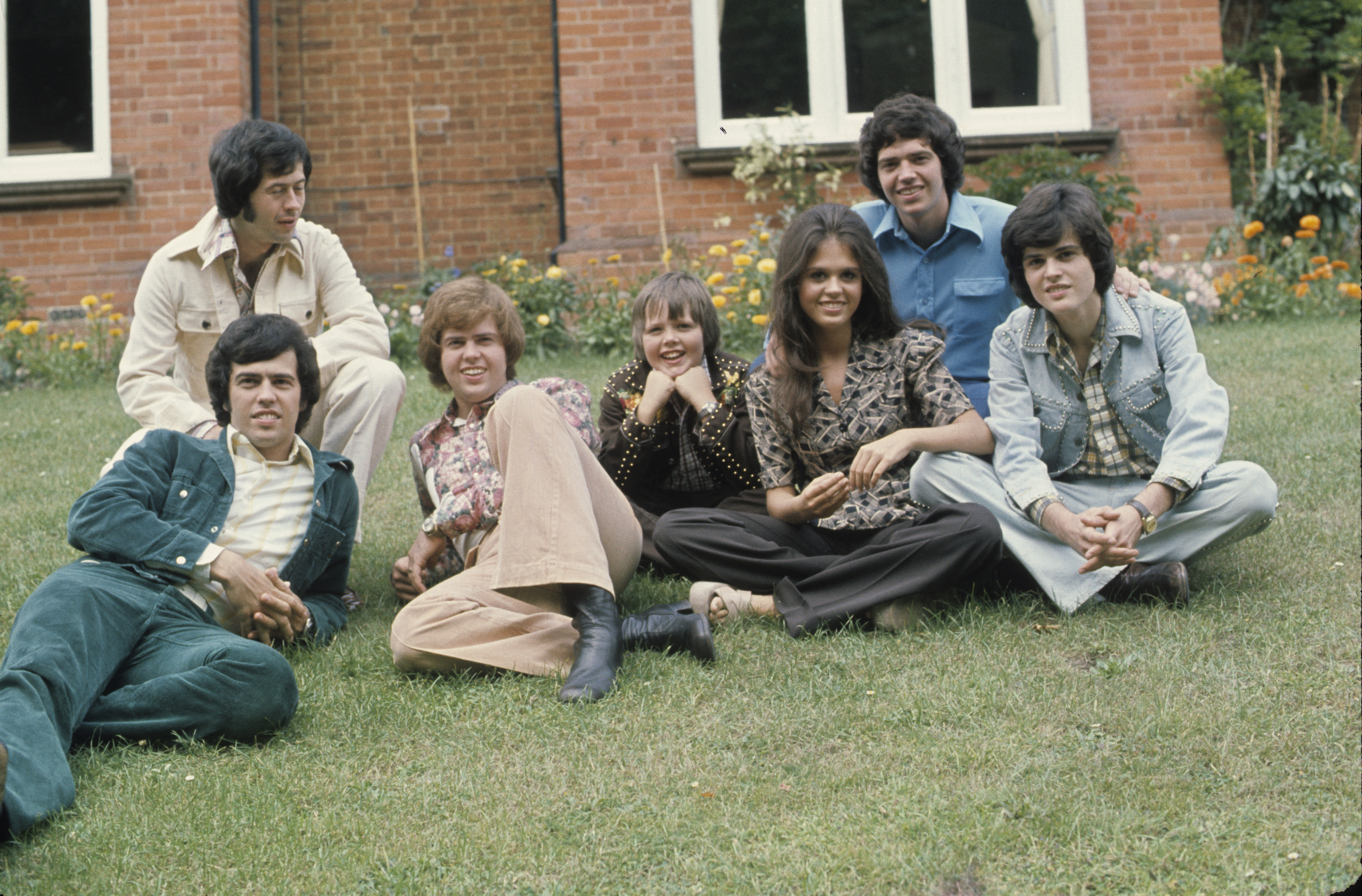 Wayne Osmond, Jay Osmond, Merrill Osmond, Jimmy Osmond, Marie Osmond, Alan Osmond, and Donny Osmond in England in 1974 | Source: Getty Images