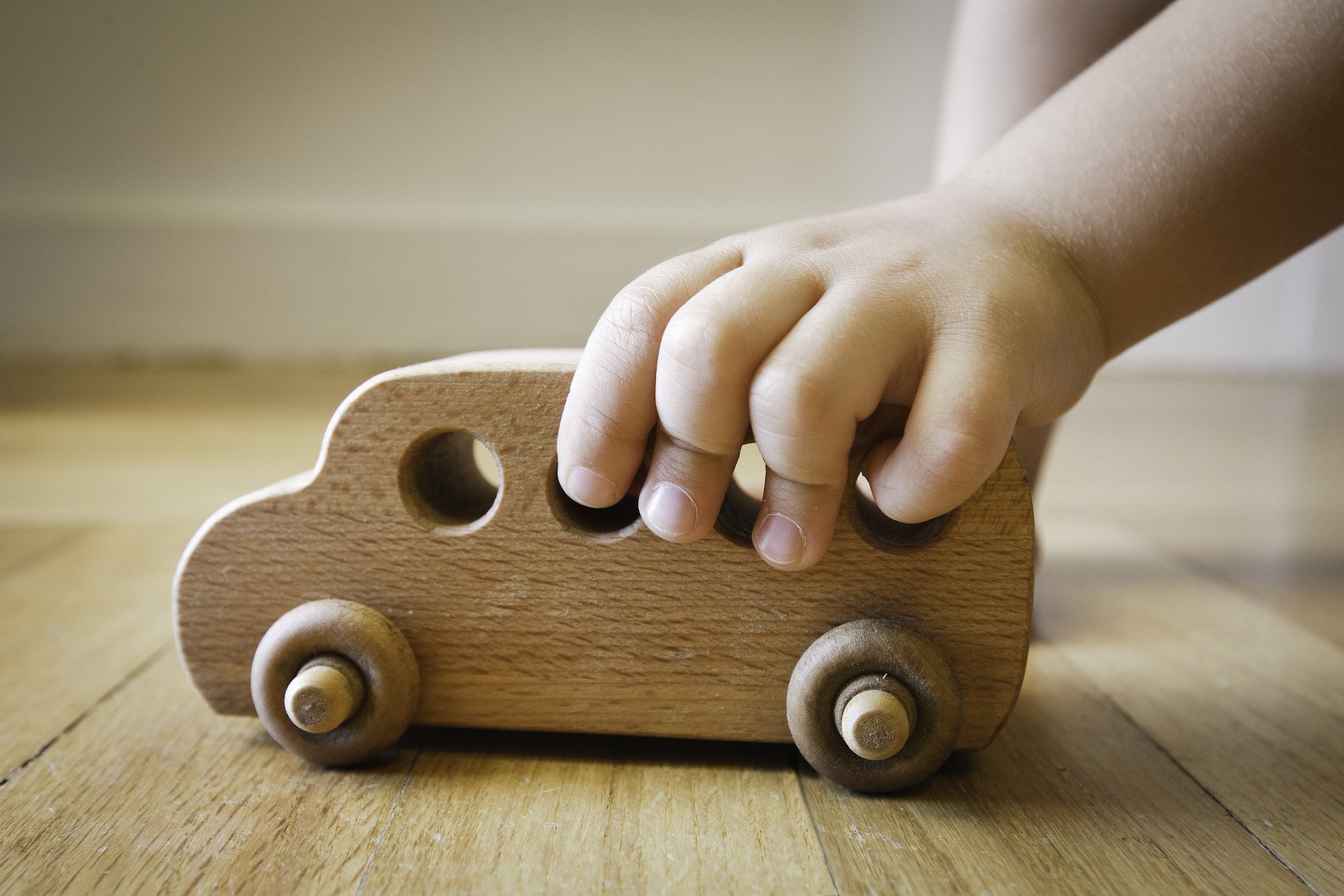 Kind spielt mit einem hölzernen Autospielzeug I Quelle: Getty Images