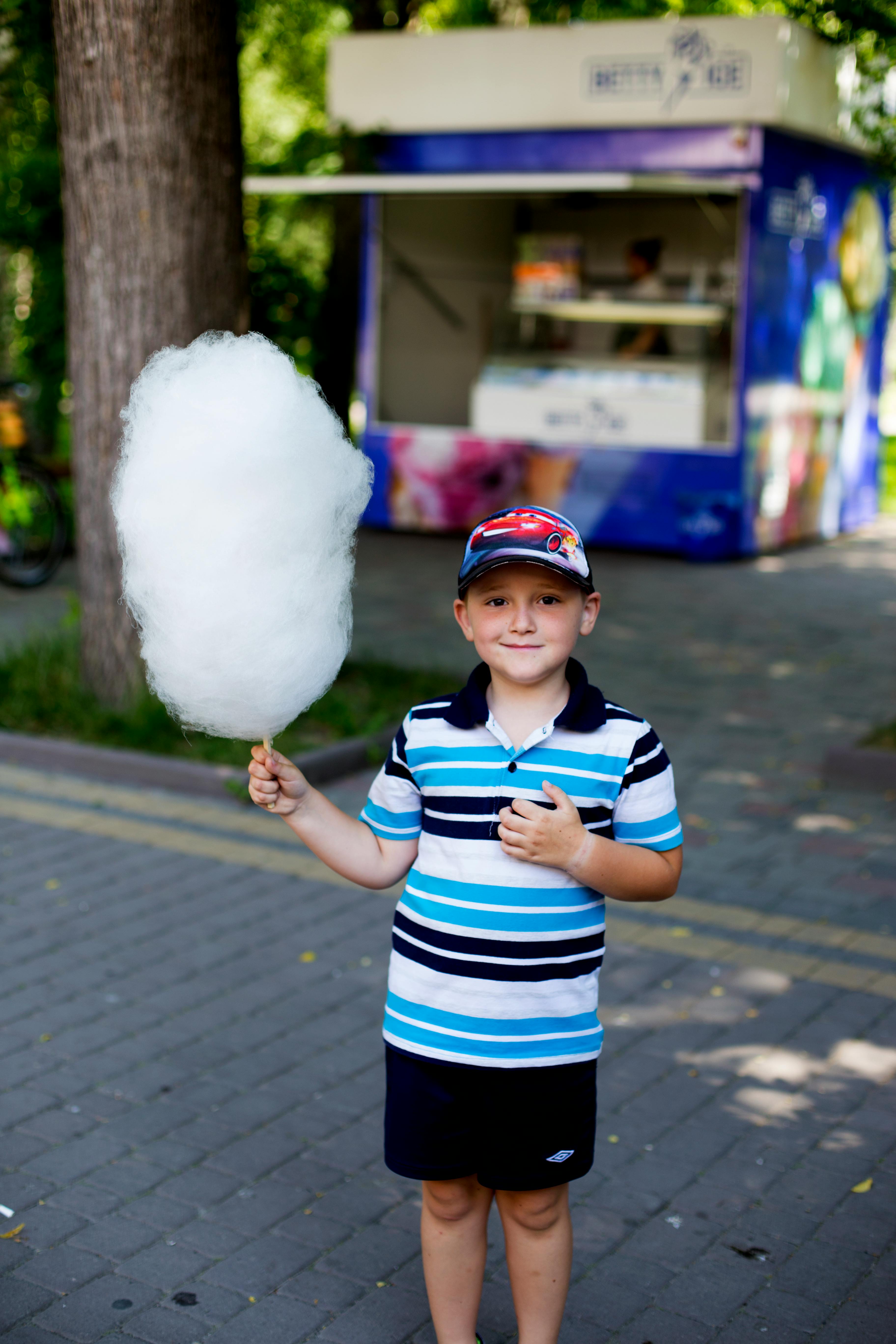 A boy posing with cotton candy | Source: Pexels