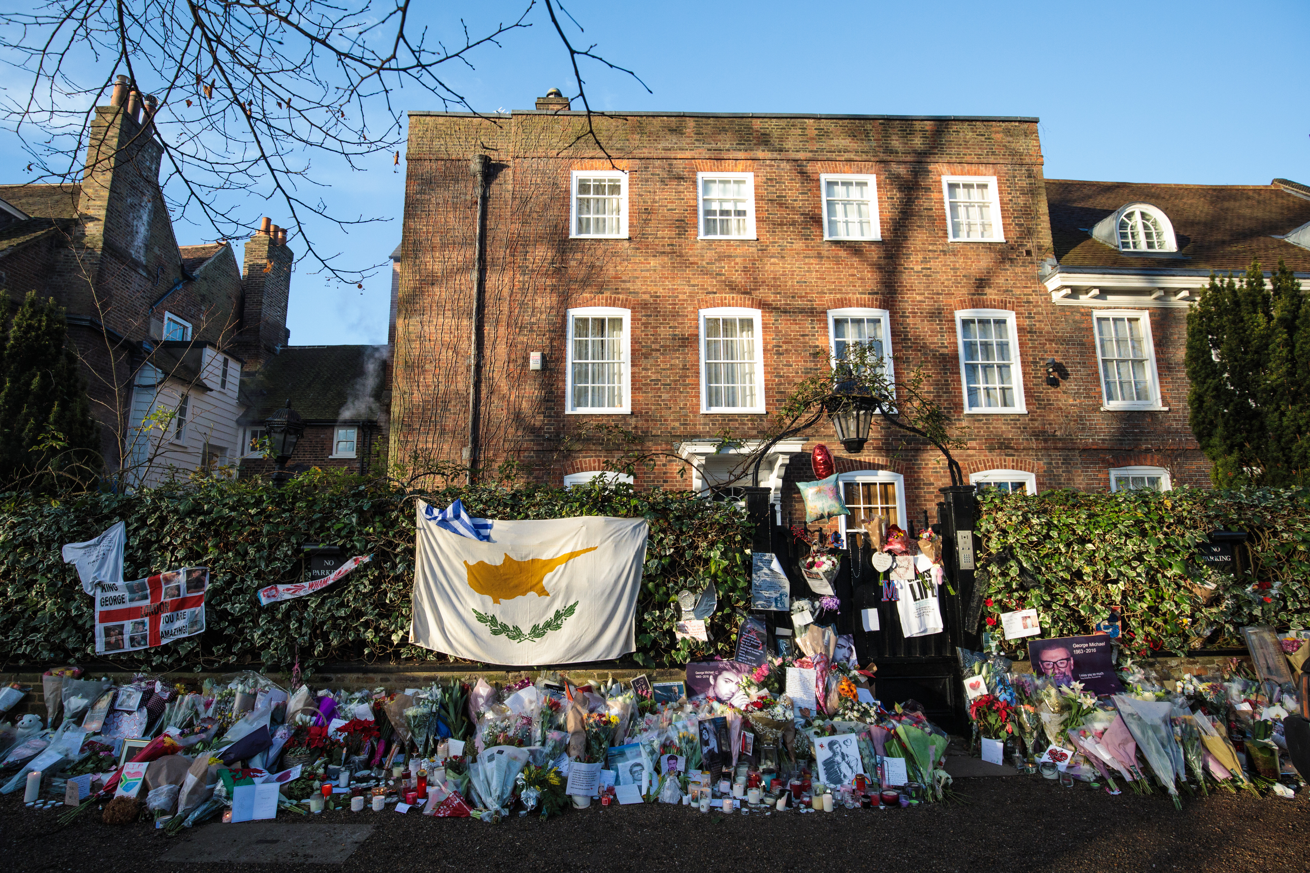 Tributes of flowers, photographs, and candles pictured outside the home of George Michael in The Grove, Highgate on December 28, 2016 in London, England | Source: Getty Images