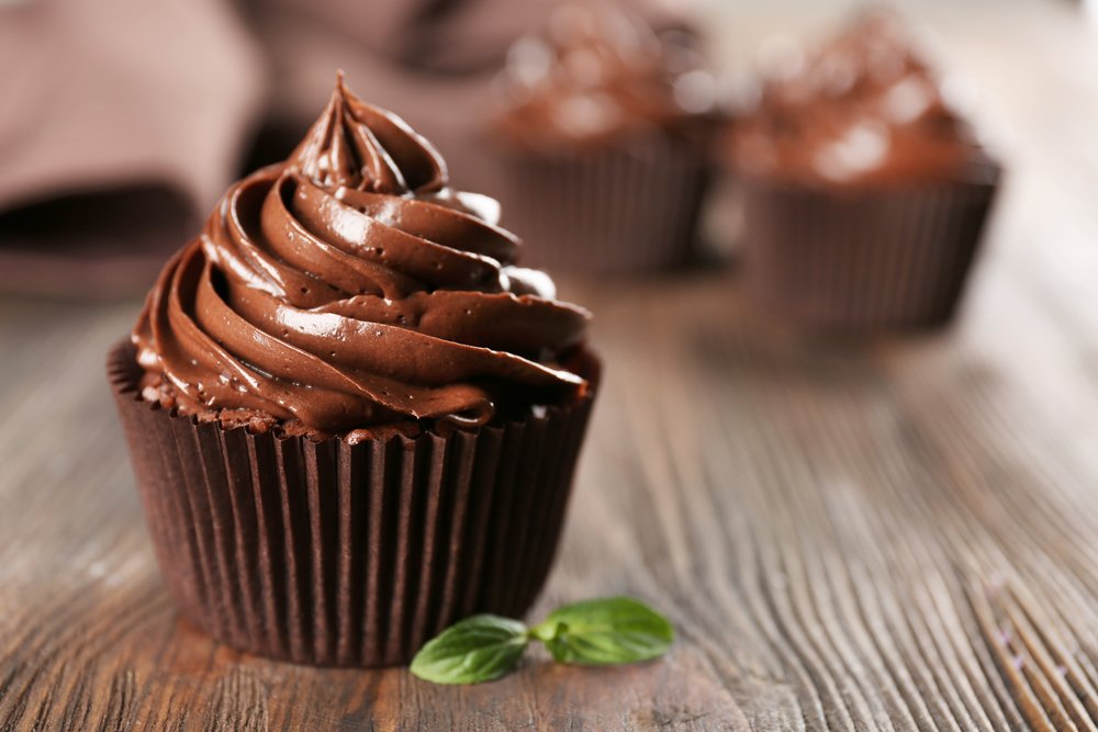 Petits gâteaux au chocolat sur une table en bois. | Shutterstock