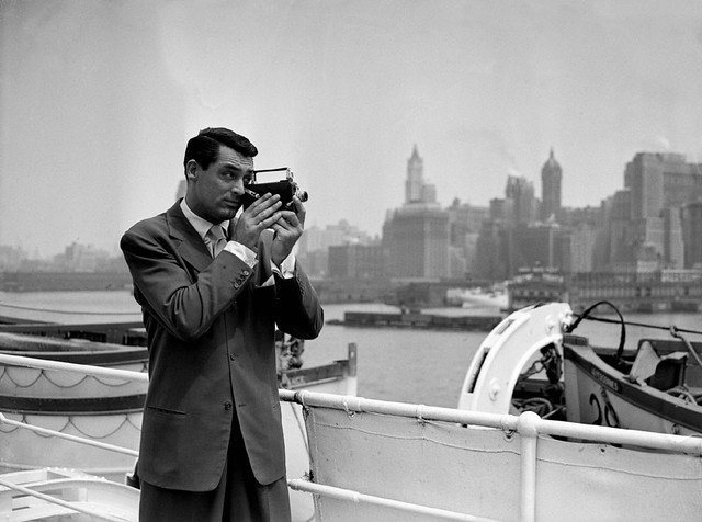 Cary Grant takes pot shots with his camera at the New York skyline, as he comes up the bay on the S.S. Ile de France on July, 8 1938 | Photo: Getty Images