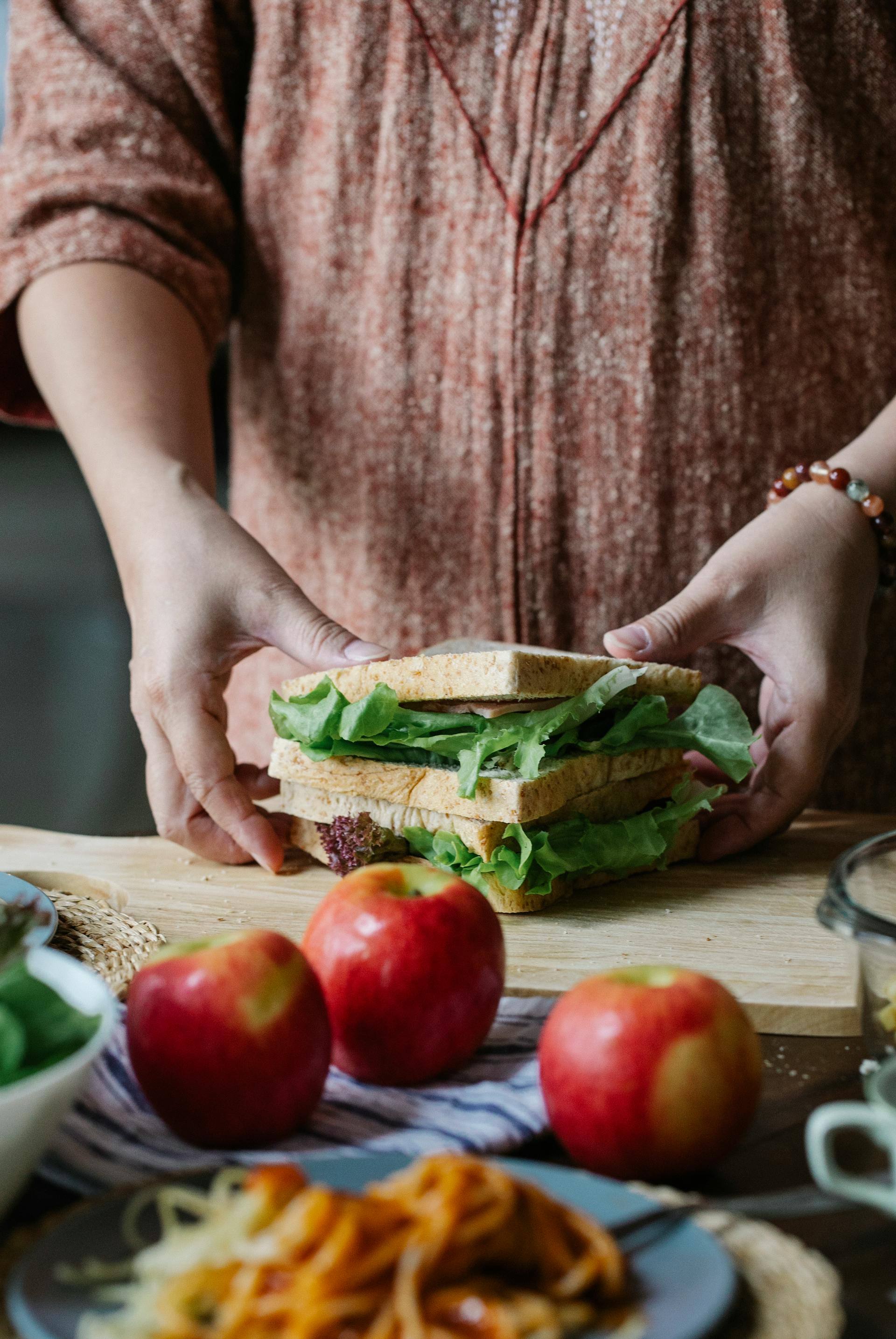 A closeup shot of a woman preparing a sandwich | Source: Pexels