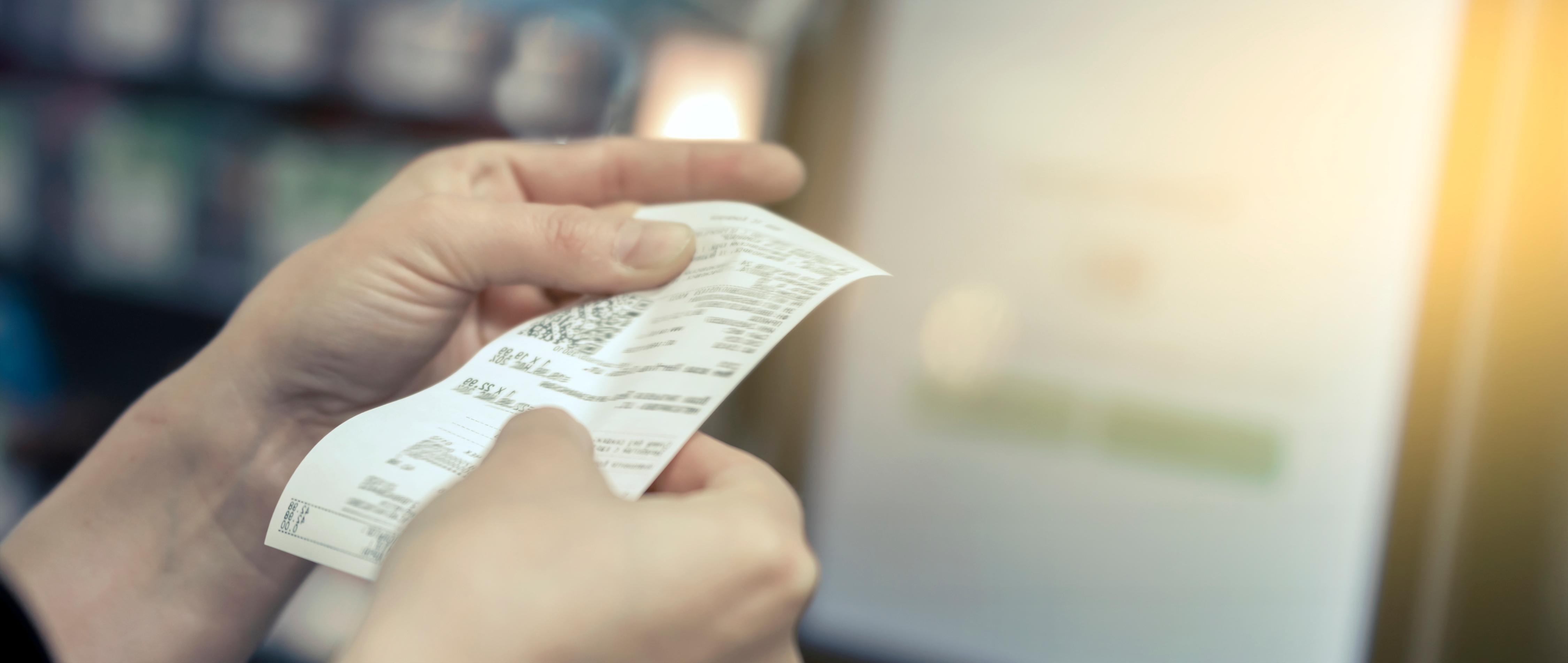 A woman holding a grocery store receipt | Source: Shutterstock
