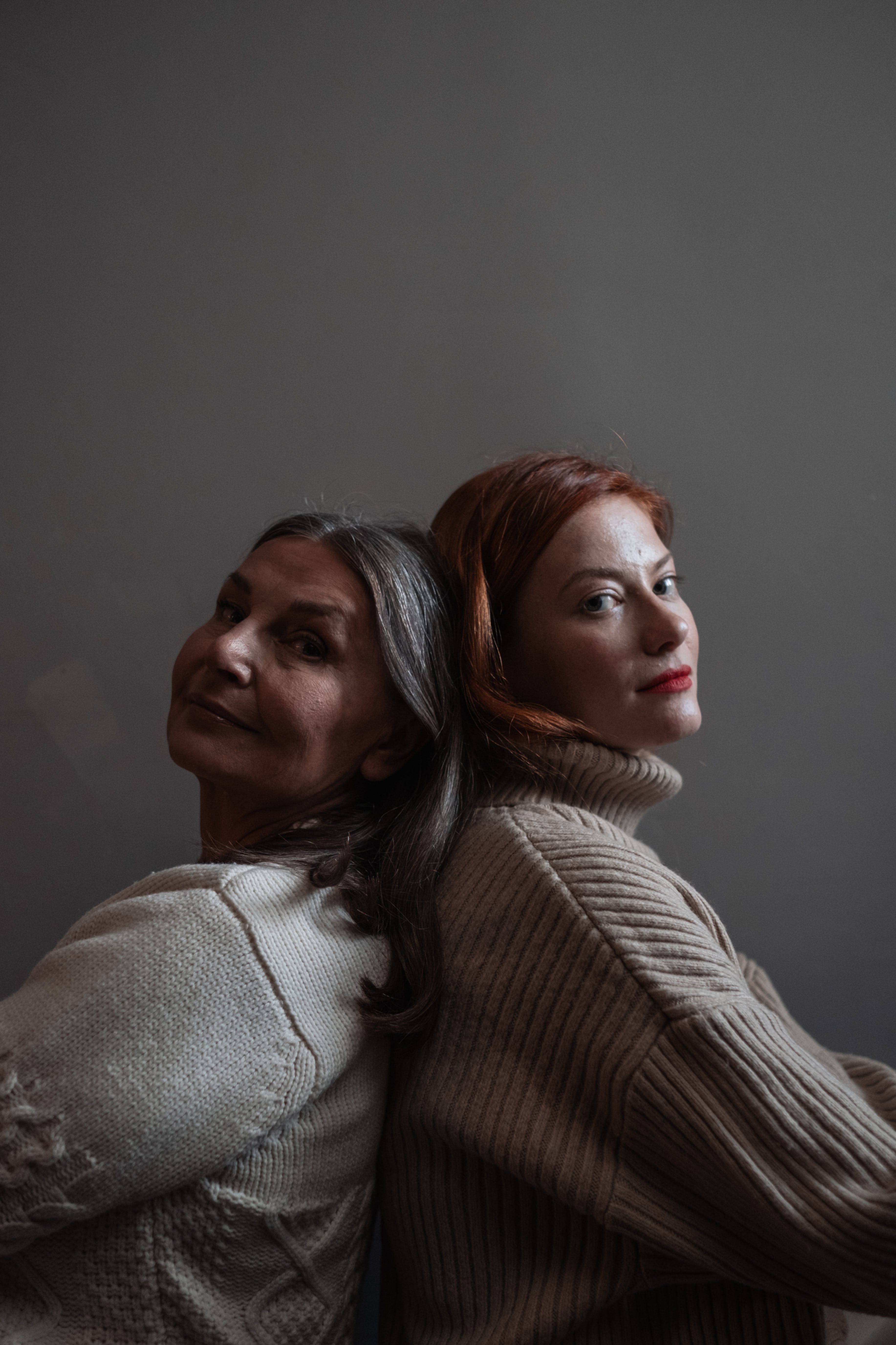 Mother and daughter leaning on each other's backs | Source: Pexels
