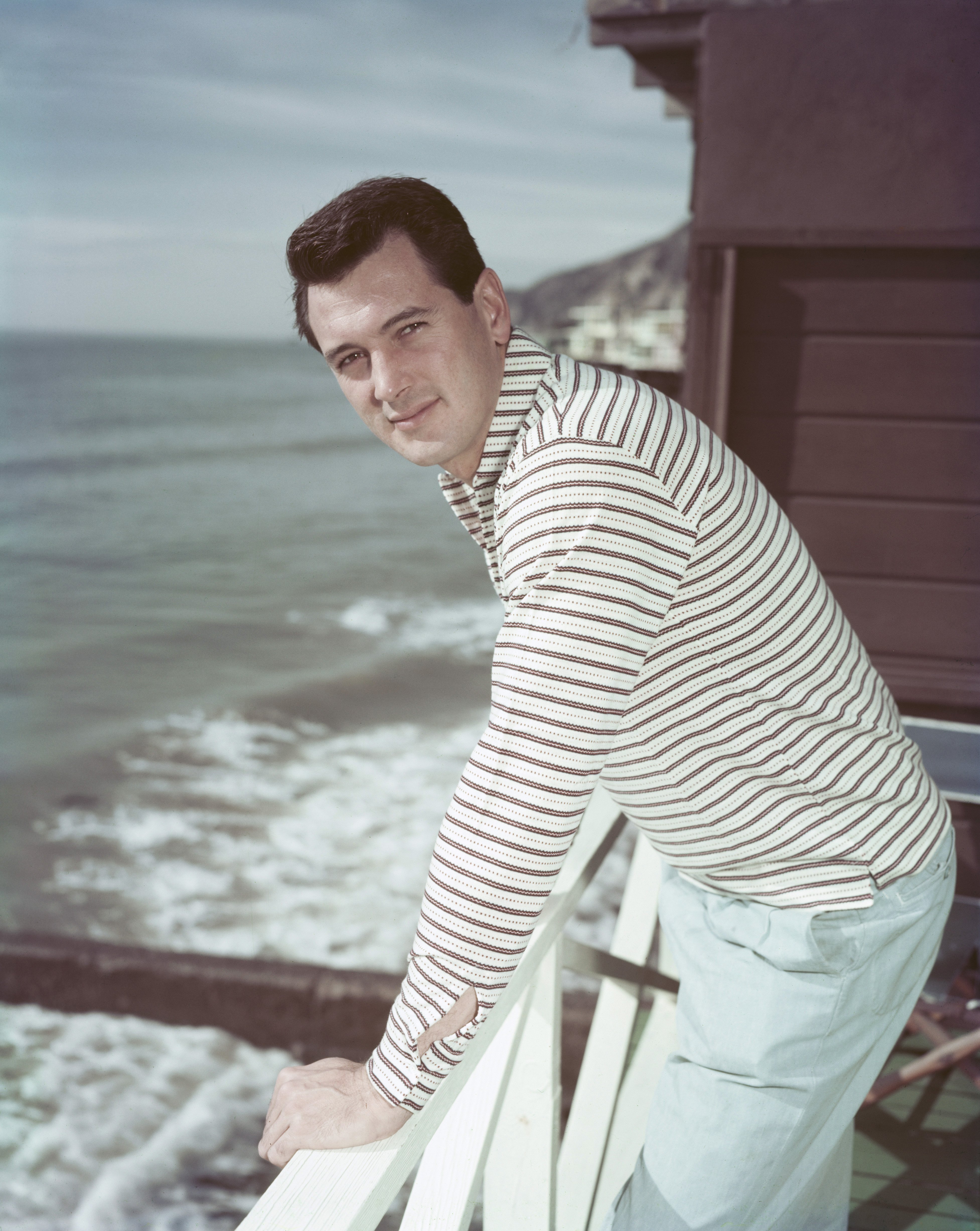 Rock Hudson posing on the deck of his Malibu beach house in 1958 | Source: Getty Images