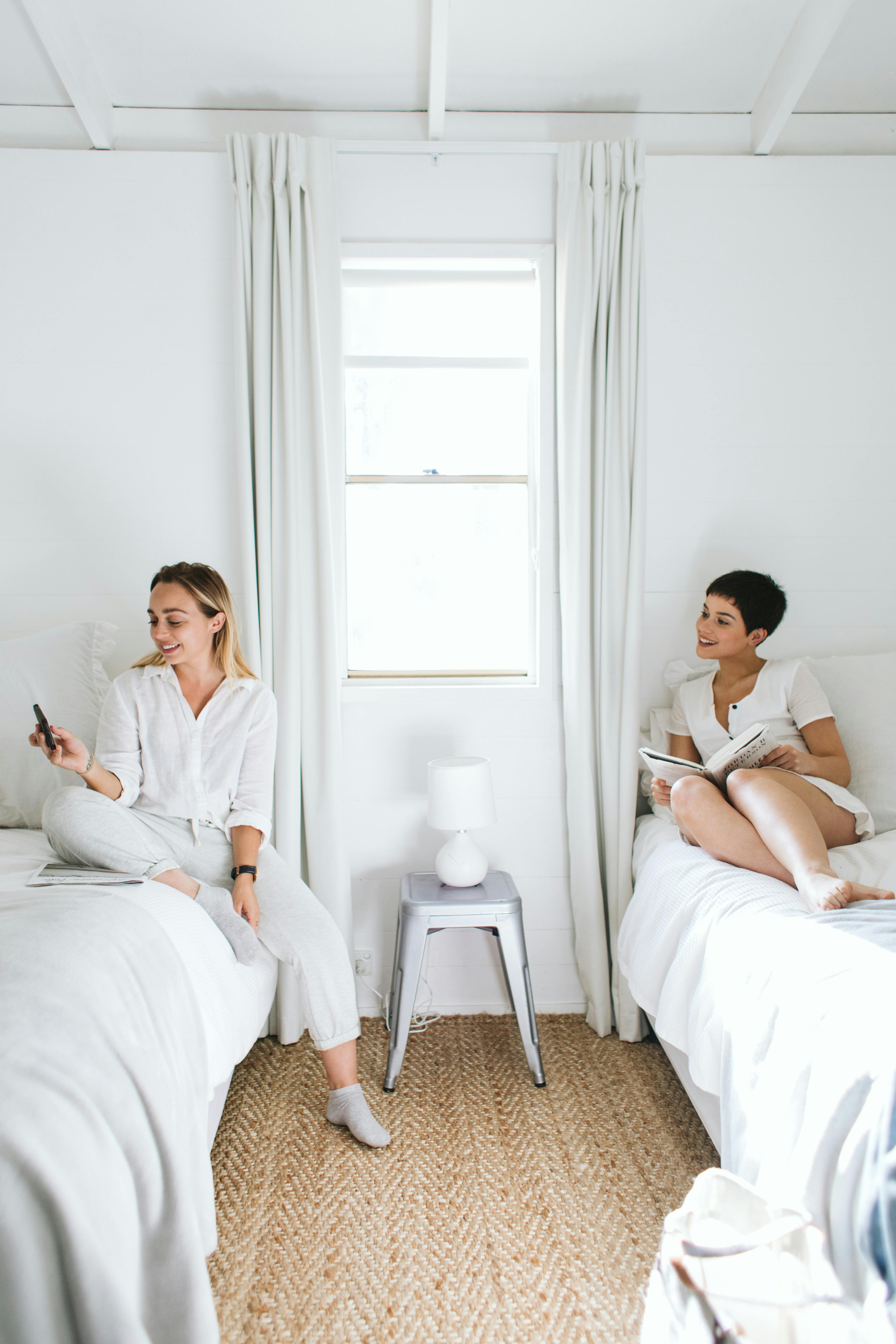 Two women sitting on individual beds | Source: Pexels