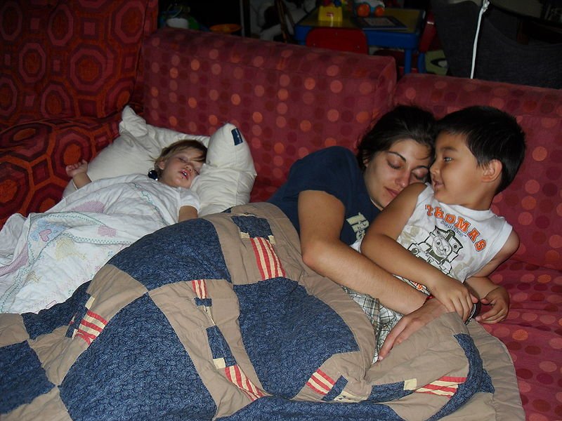 Madre junto a sus dos hijos recostados en un sofá. | Imagen: Wikimedia Commons Madre junto a sus dos hijos recostados en un sofá. | Imagen: Wikimedia Commons