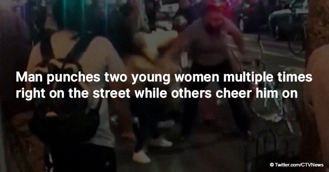 Man punches two young women multiple times right on the street while others cheer him on