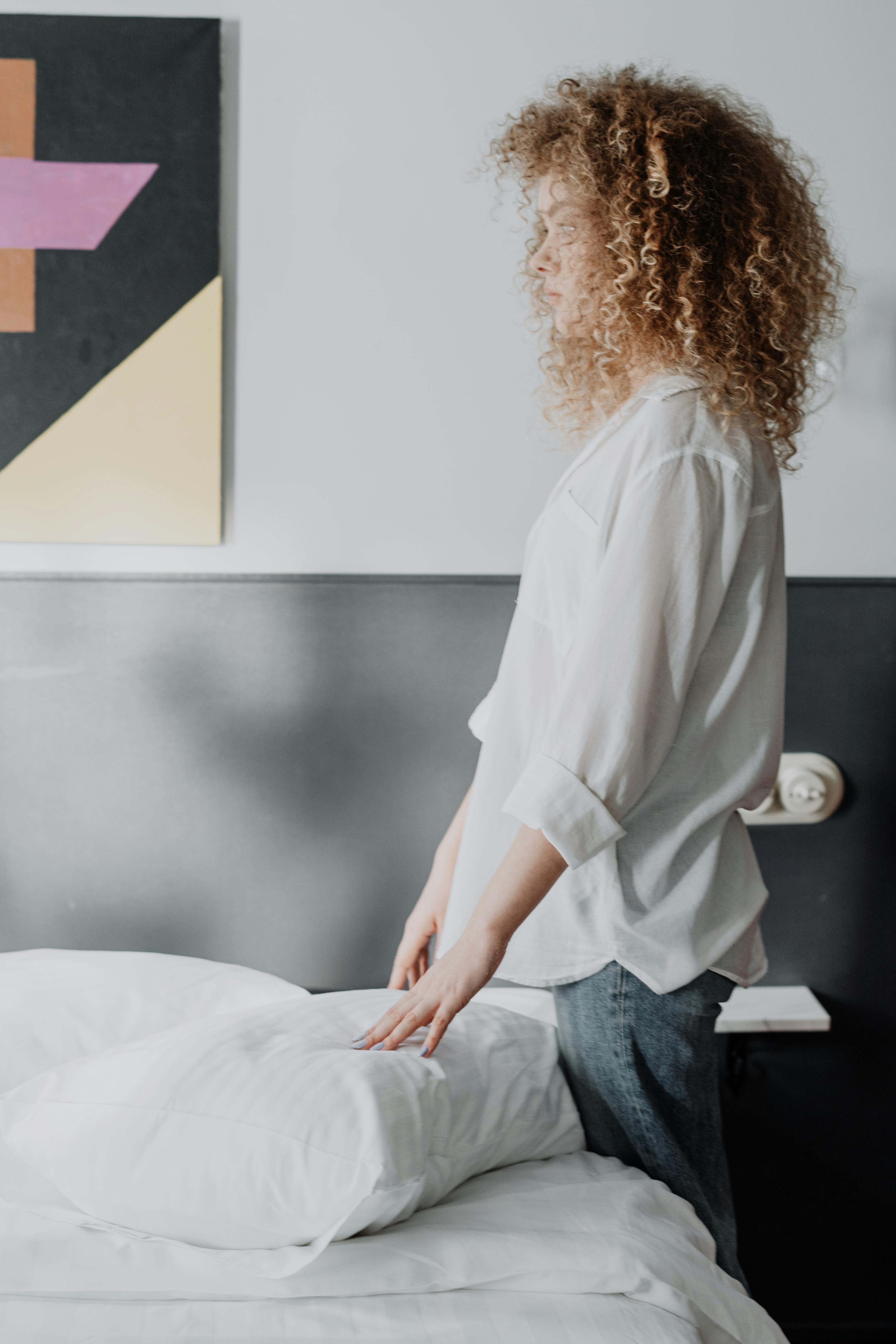 A woman standing by a bed | Source: Pexels