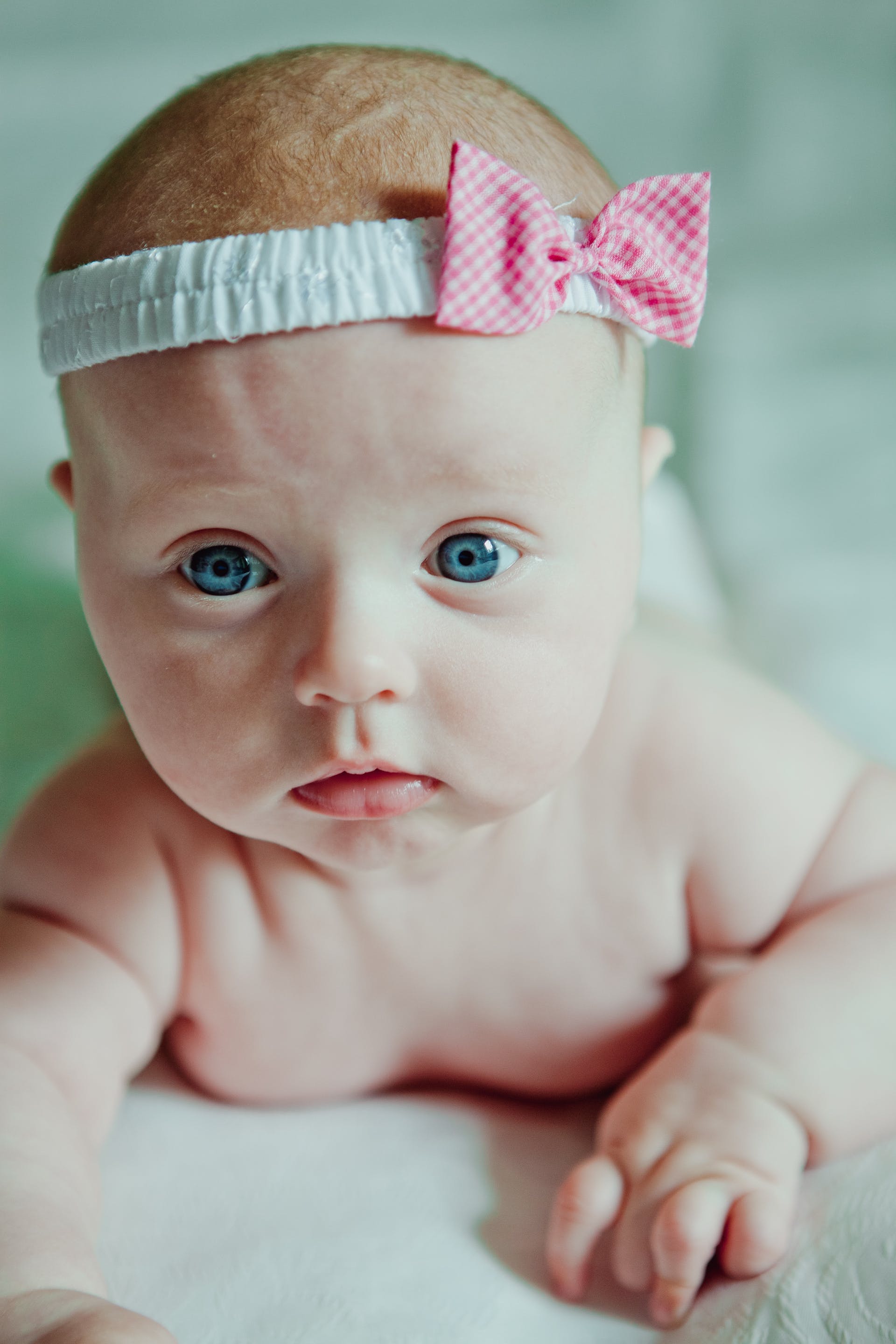 A close-up shot of a newborn with blue eyes and a headband | Source: Pexels