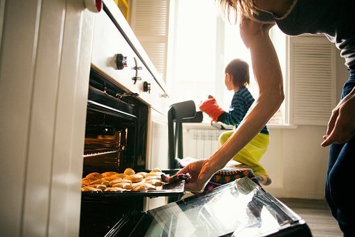 Mother and son baking cookies in kitchen | Photo: Getty Images