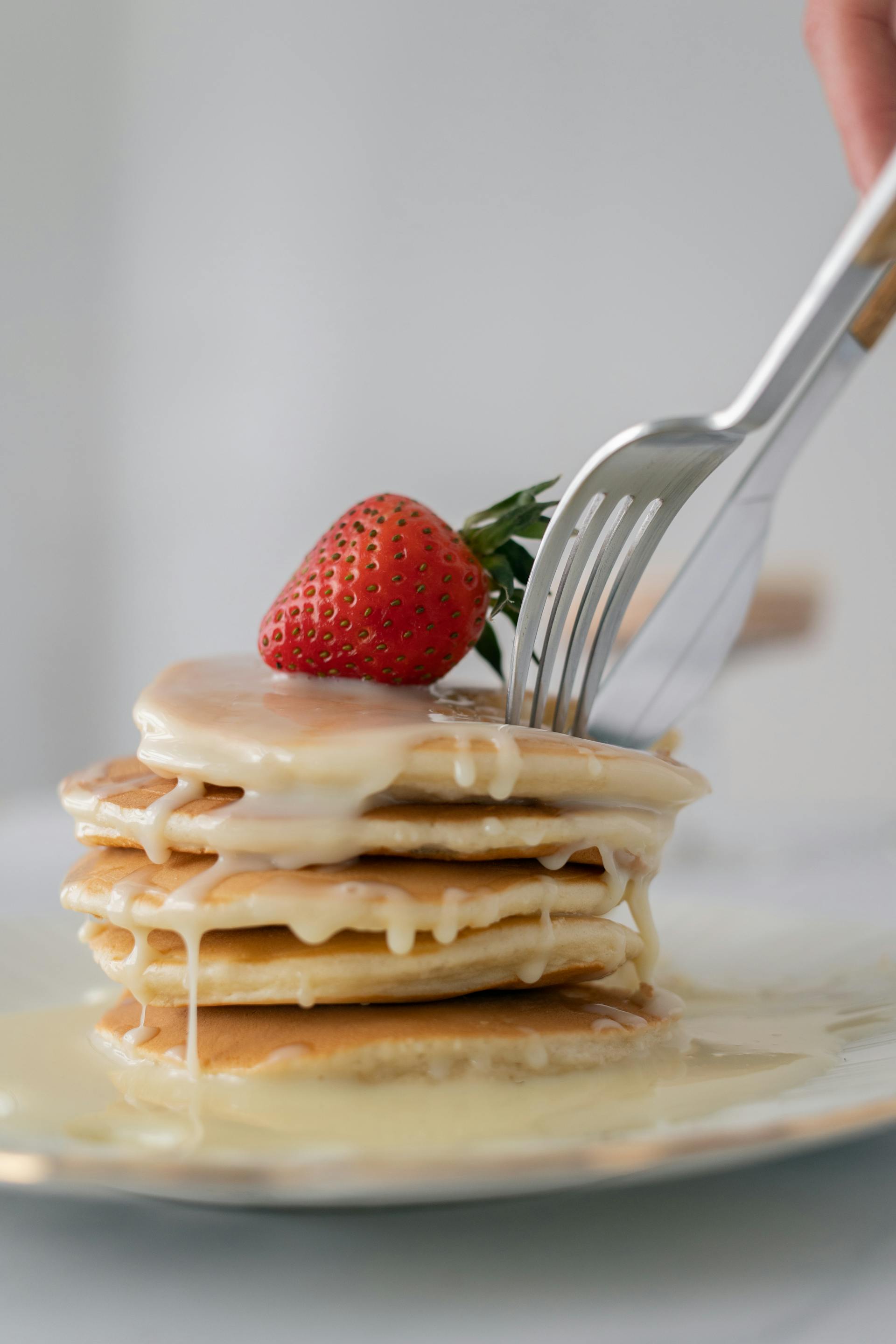 A person cutting pancakes | Source: Pexels