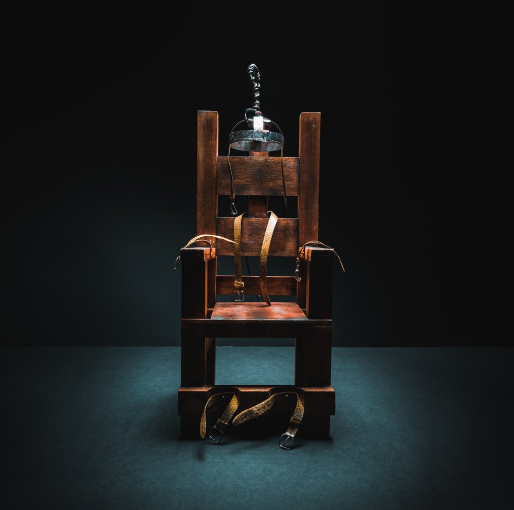 An image of an electric chair scale model on a dark background. | Photo: Shutterstock