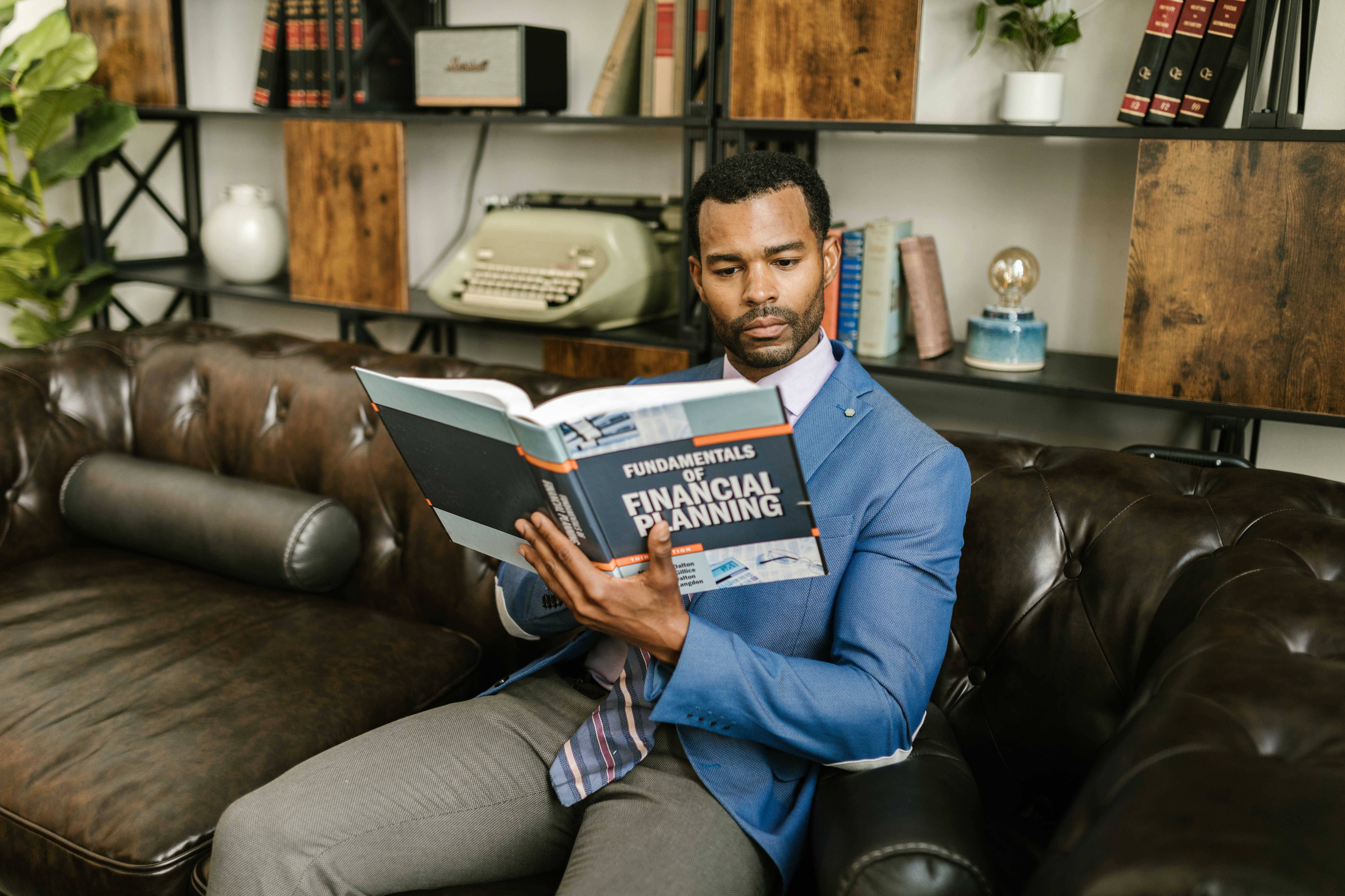 A man reading about the "Fundamentals of Financial Planning" | Source: Pexels