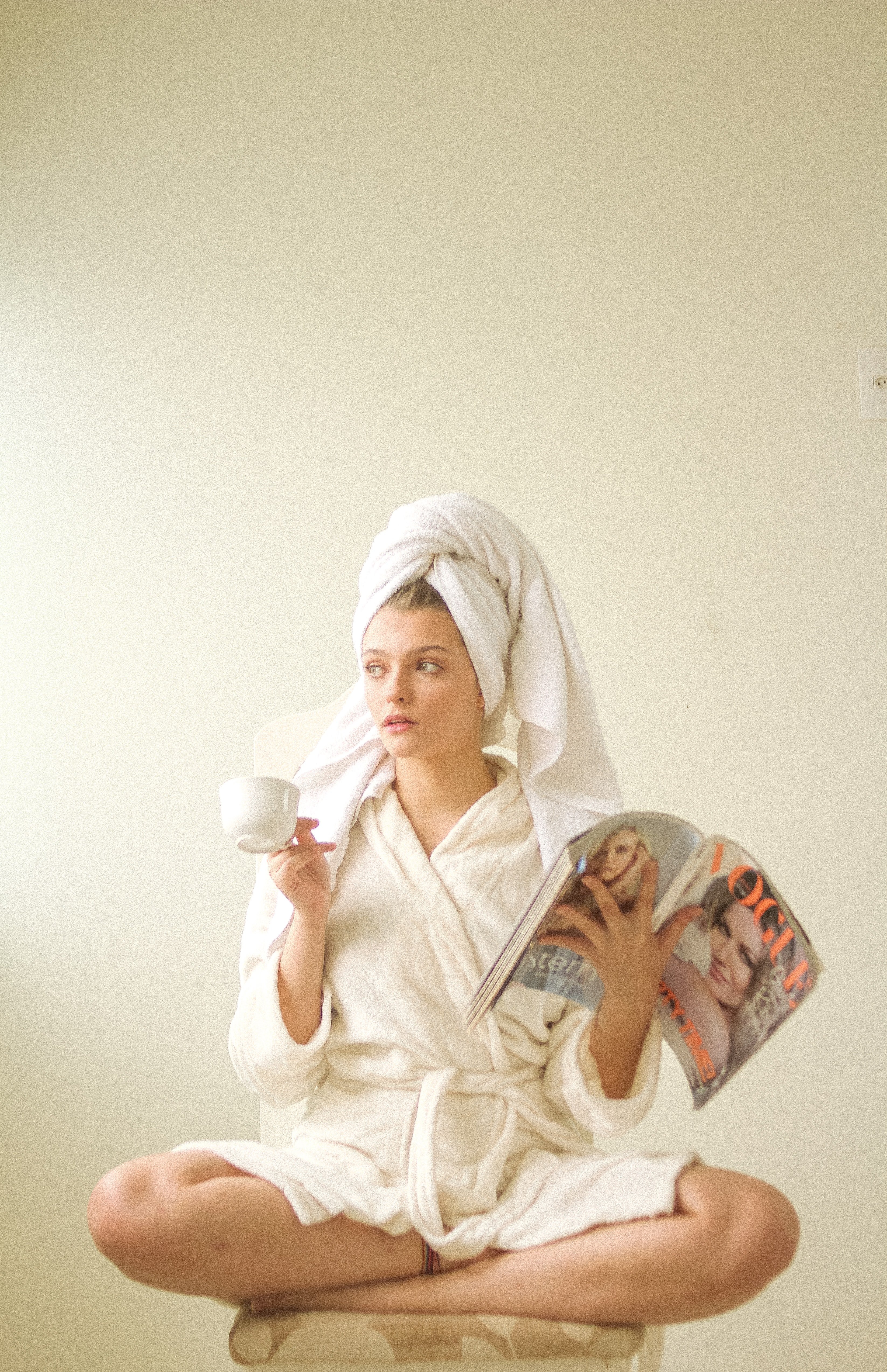 Woman in robe reading magazine | Unsplash 