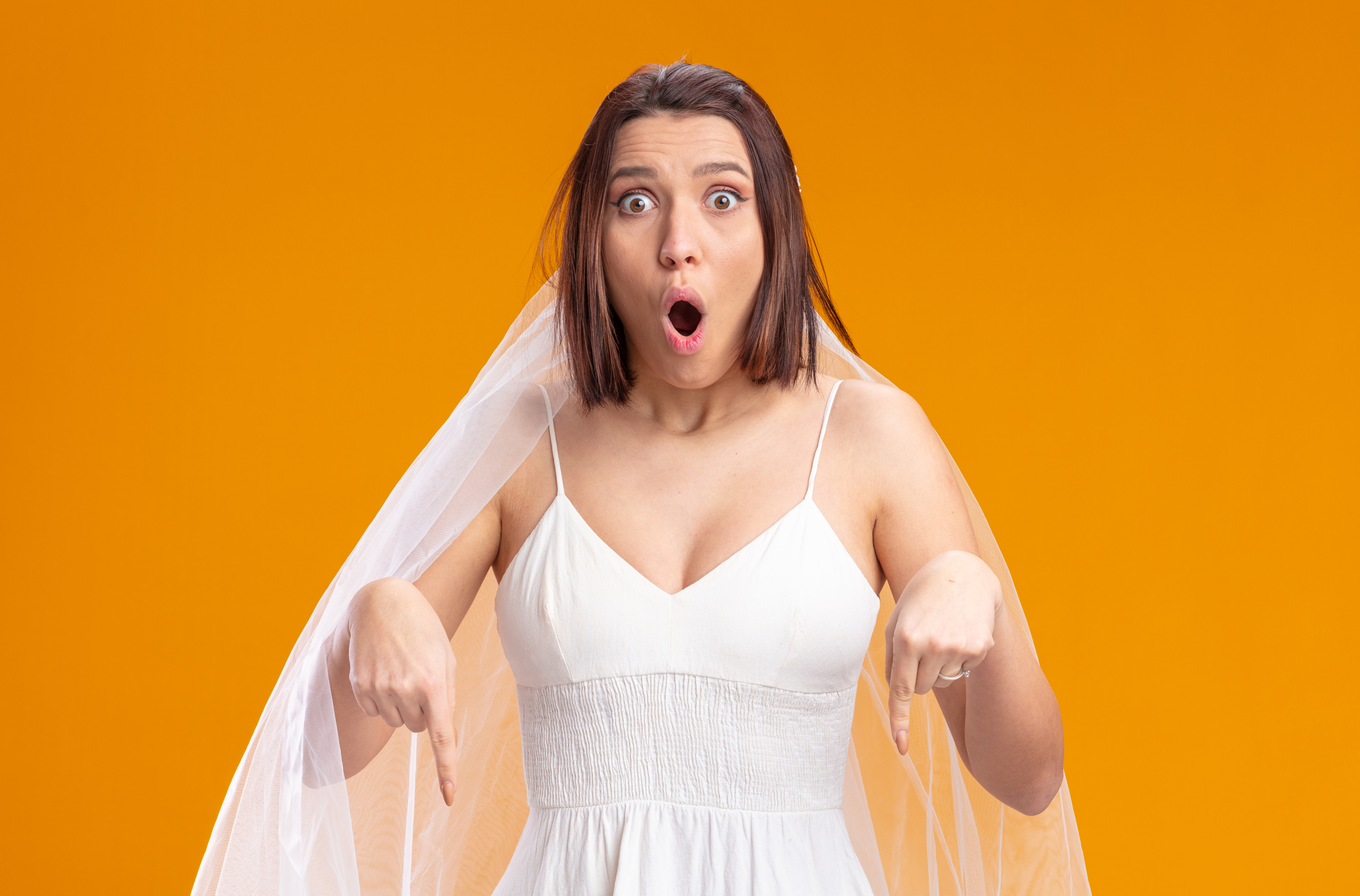 Bride looking amazed while pointing down | Source: Freepik