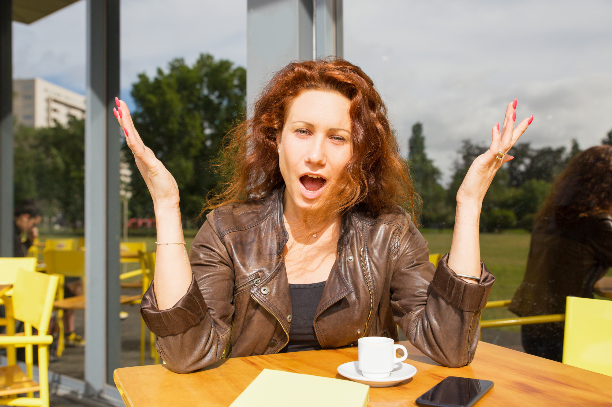 An upset woman gesturing with her hands while talking to someone at a restaurant | Source: Freepik