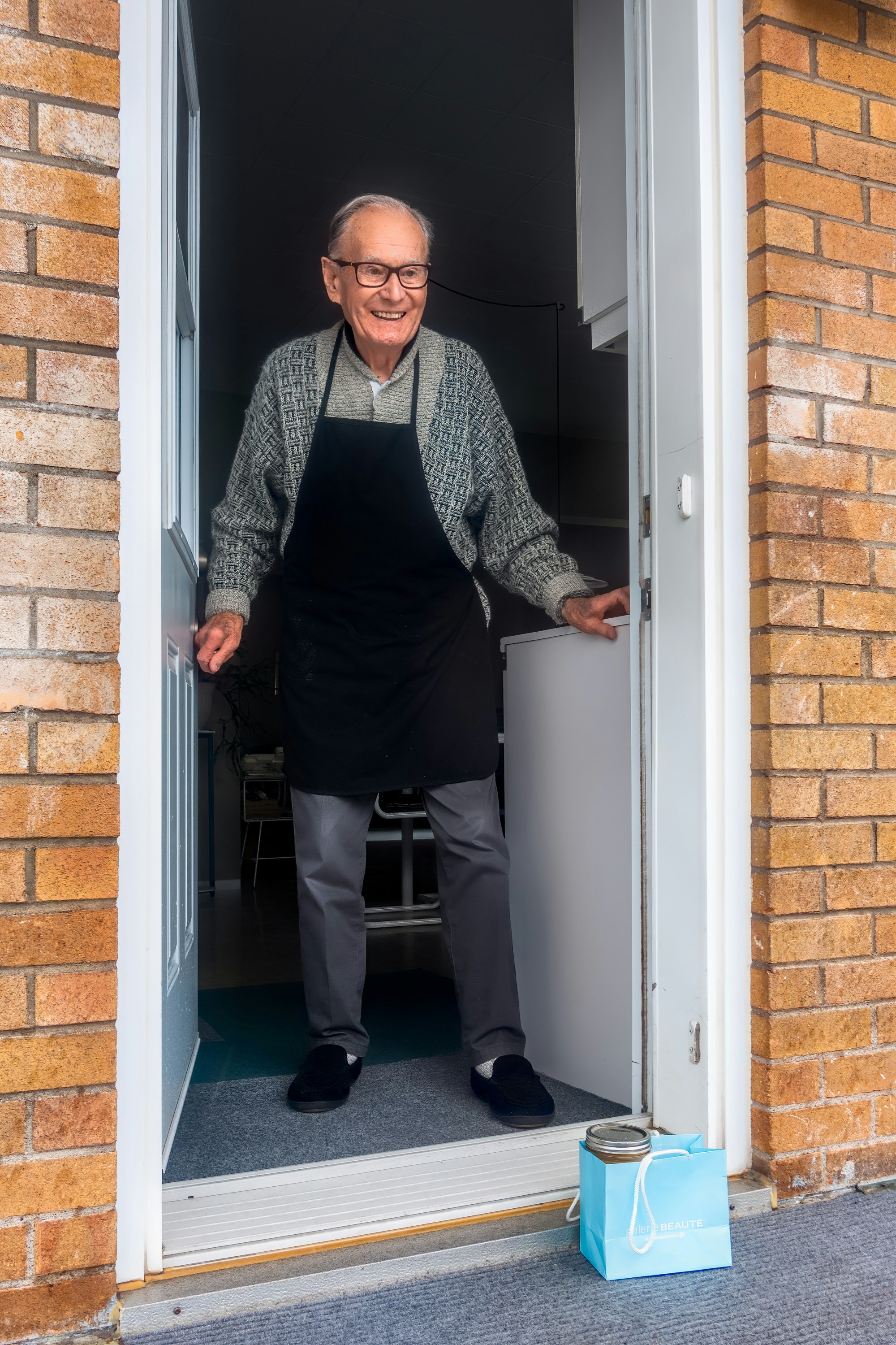 Happy elderly man standing at door entrance | Source: Unsplash