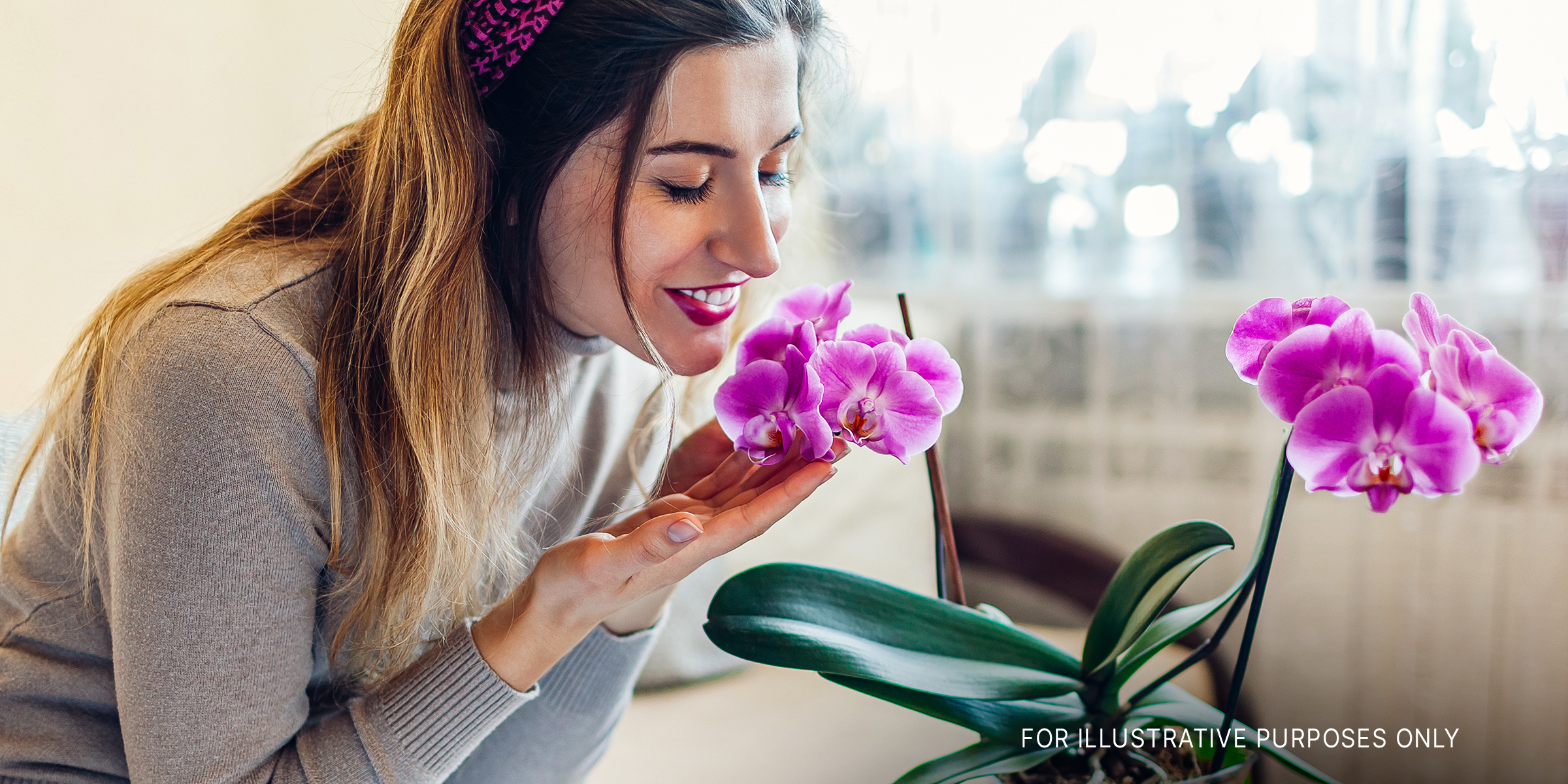 A woman smelling purple orchid flowers | Source: Shutterstock