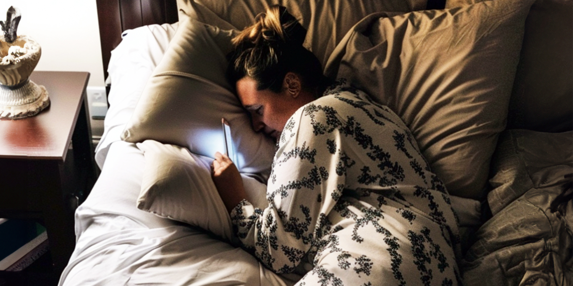 A woman using her phone in bed at night | Source: Amomama