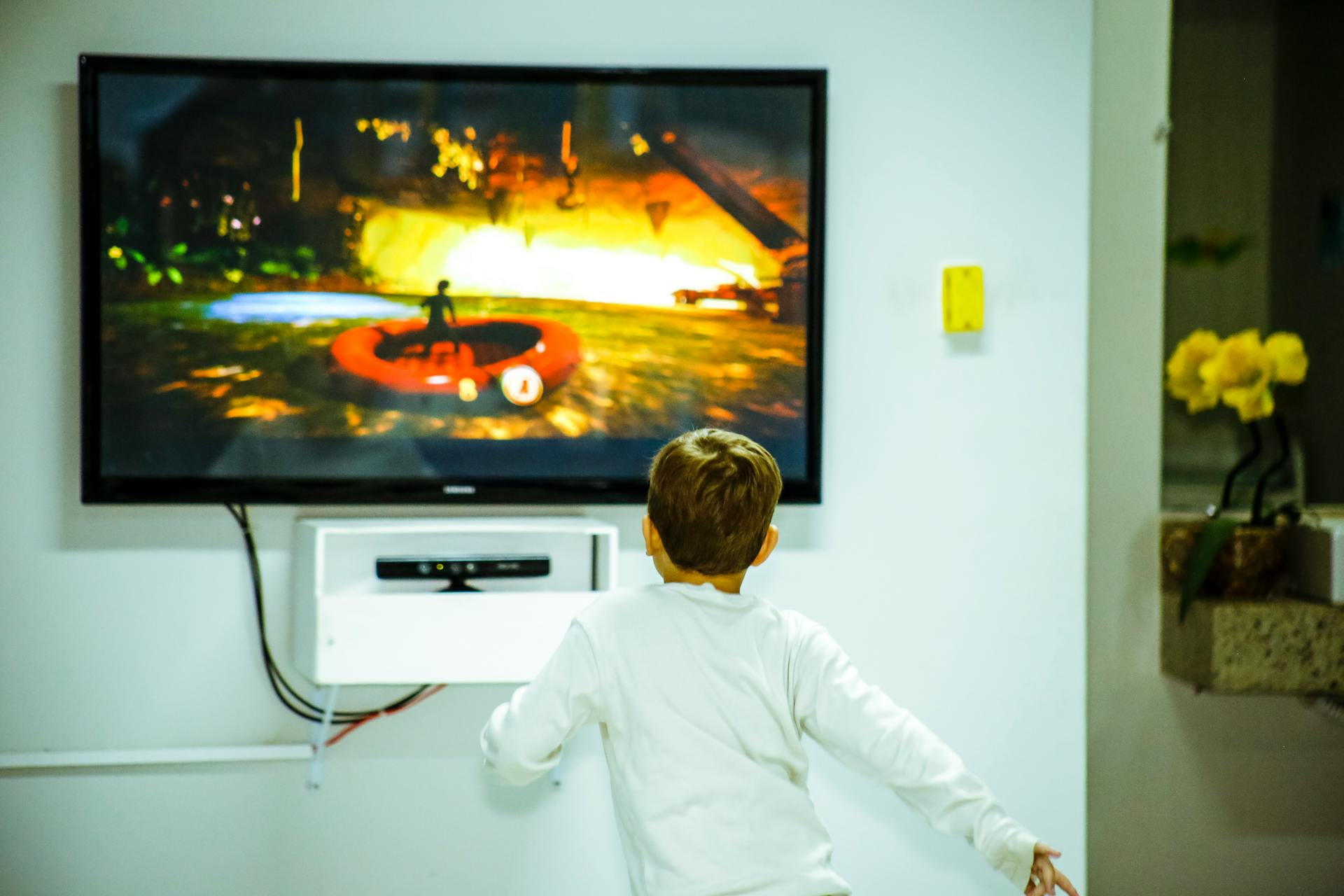 A boy standing in front of a TV | Source: Pexels